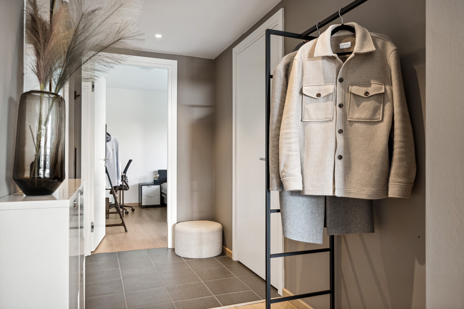 Innbydende entre som praktisk deler inn leilgiheten i soner. Galleribilde