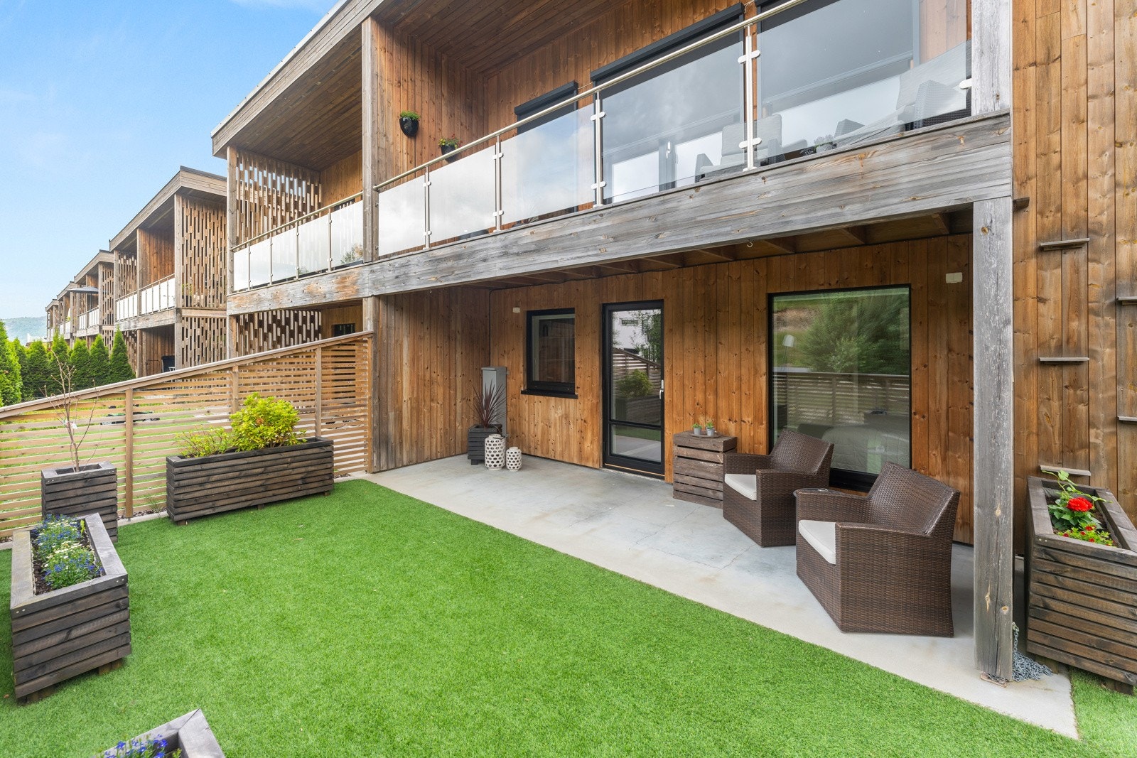 Her er det ett fint opparbeidet uteområde med støpt platting og praktisk kunstgress Galleribilde