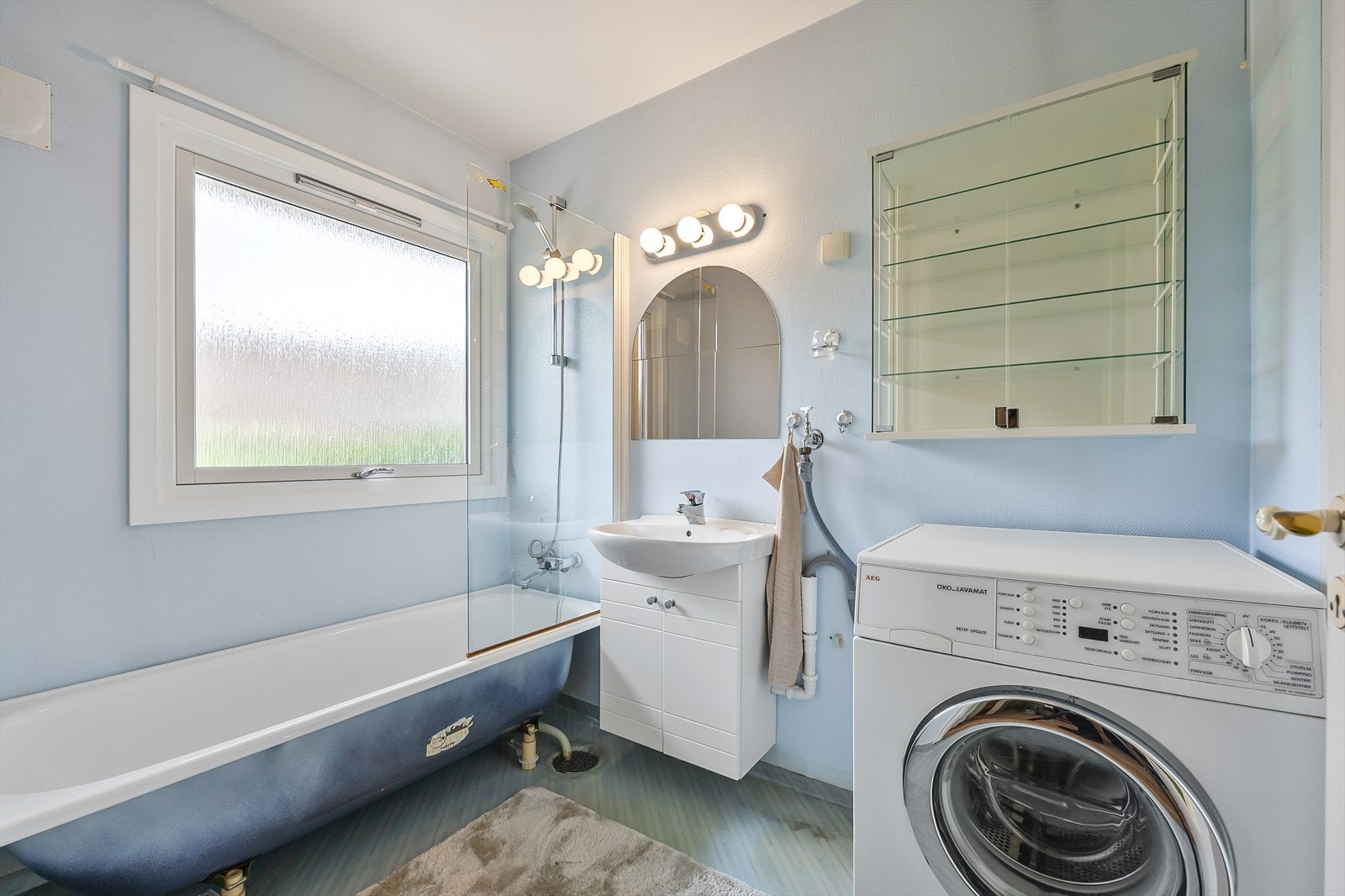 Baderom med badekar og plass for vaskemaskin. Galleribilde