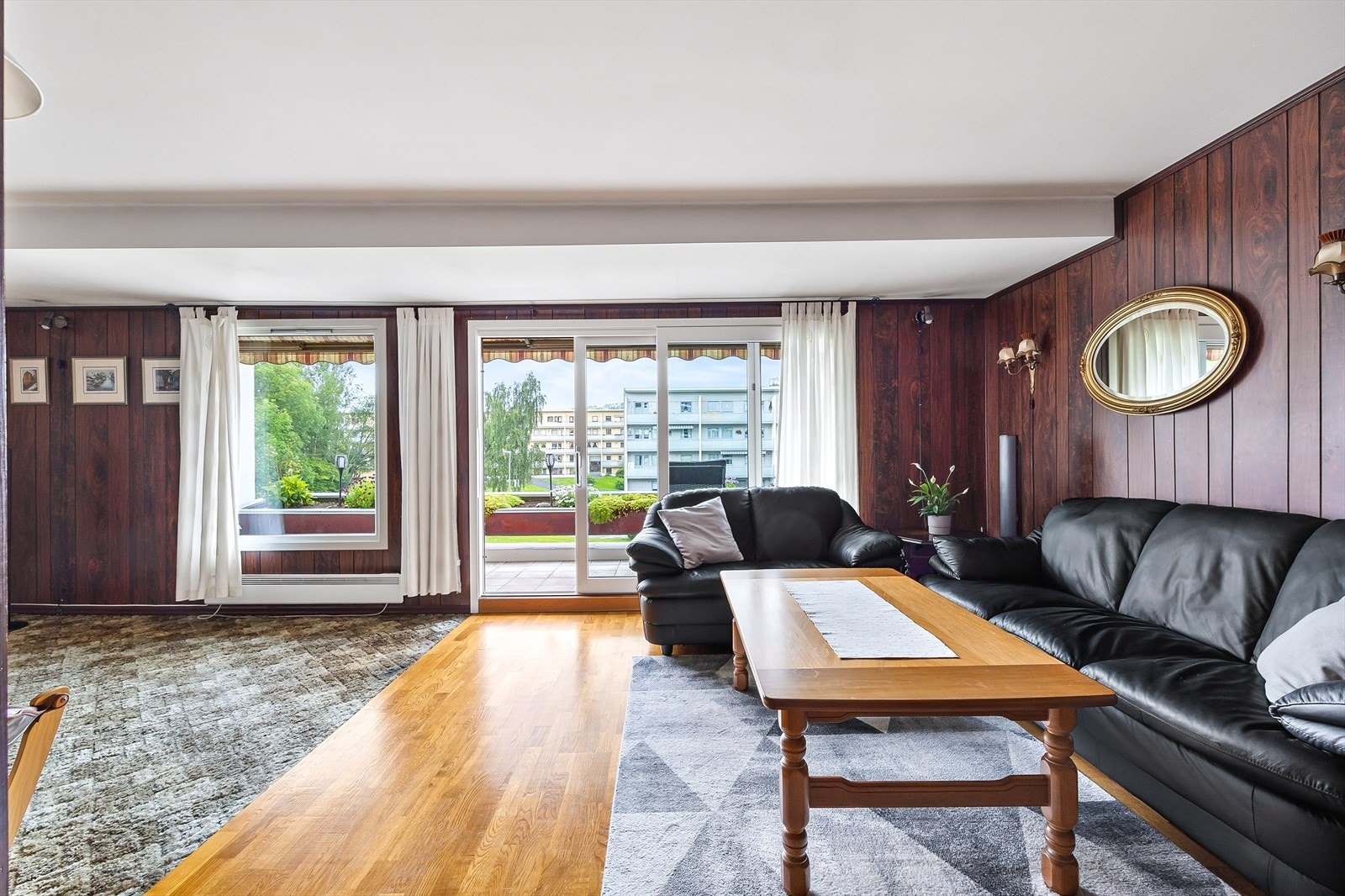 Stue med parkettgulv og utgang til balkong Galleribilde