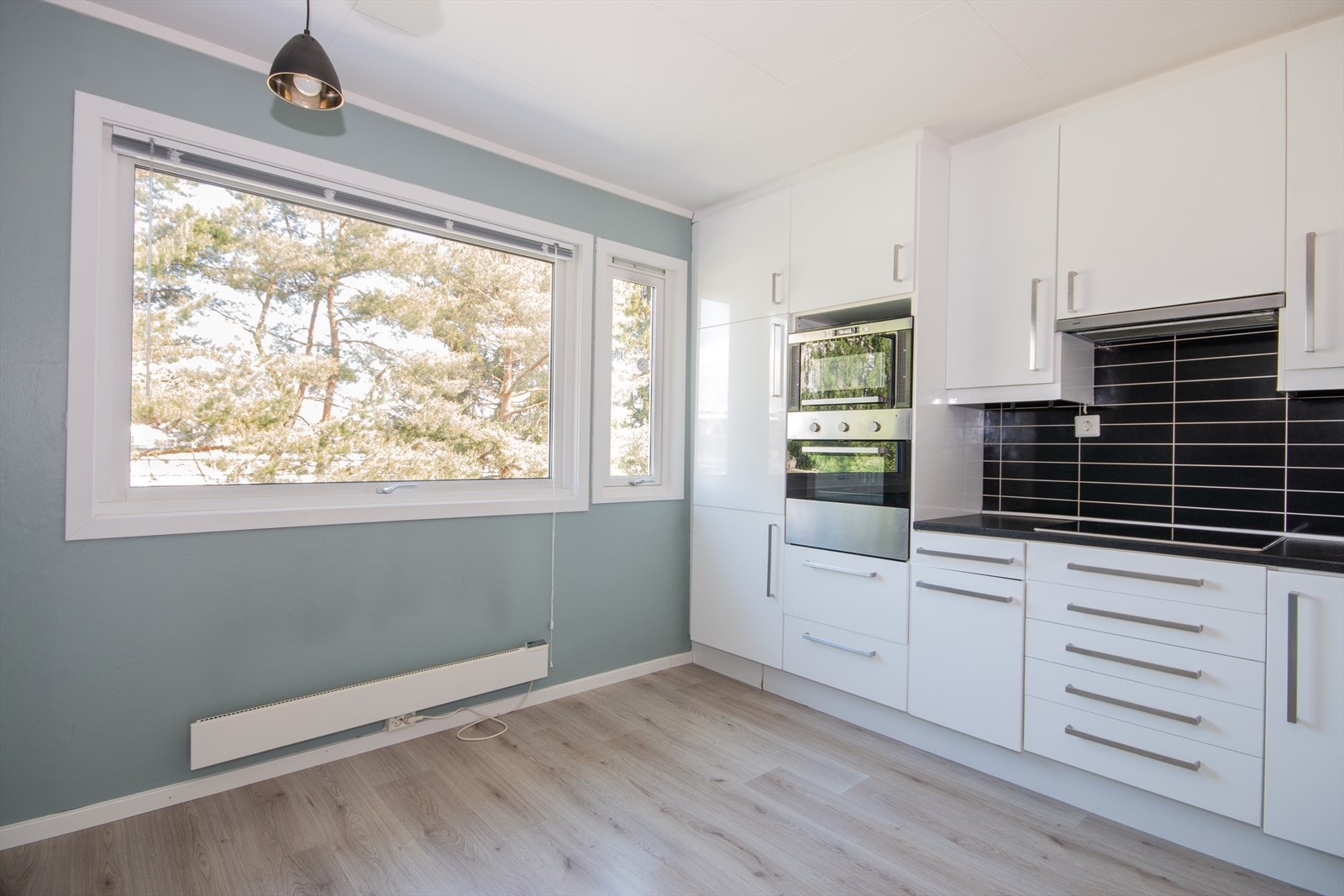 Romslig kjøkken med spiseplass ved vindusrekke. Galleribilde