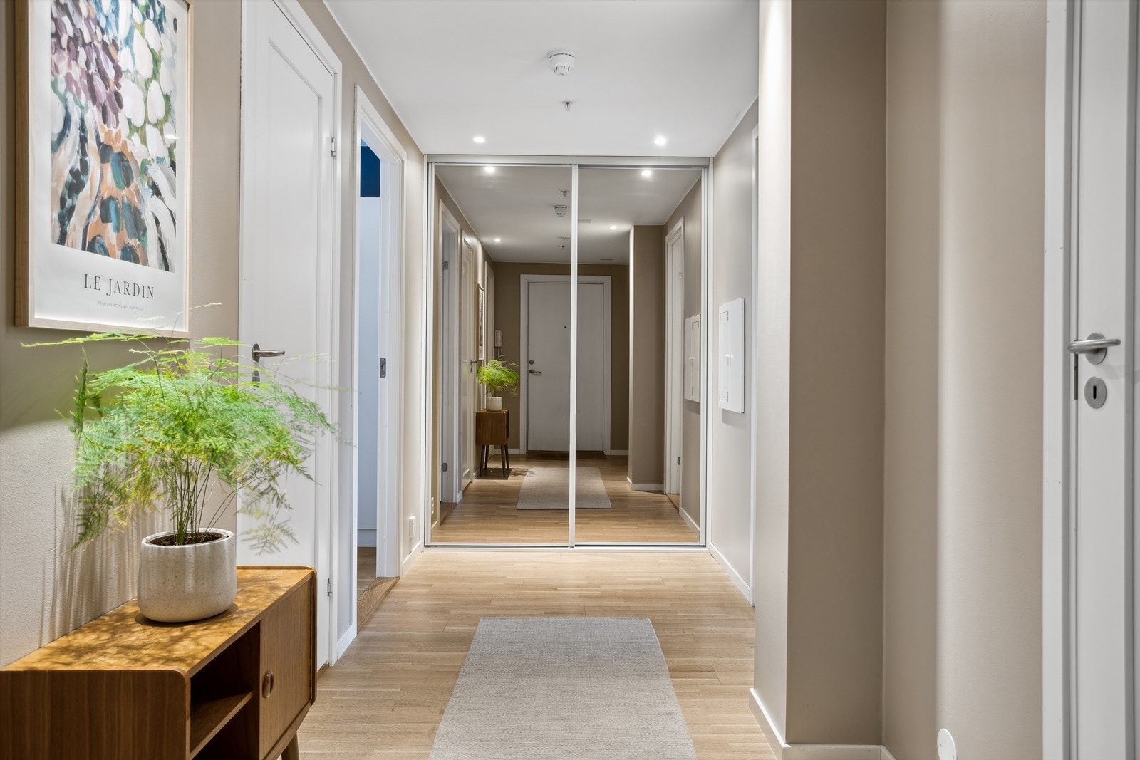 Lun og innbydende entré med parkett på gulvet, vegger nylig malt i en delikat fargetone, samt downlights i himling. Det er god oppbevaringsplass i den romslige skyvedørsgarderoben med speilfronter. Galleribilde