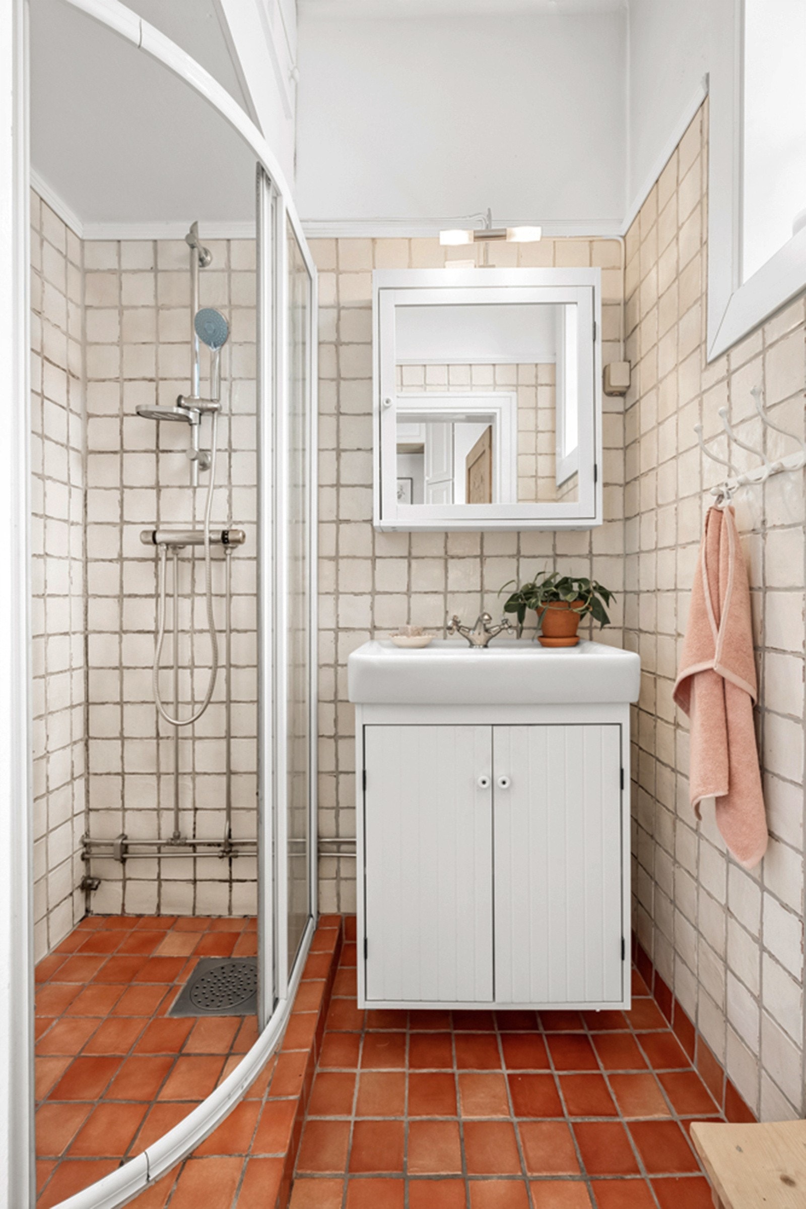 Badet i 1.etasje bærer preg av å være eldre med behov for modernisering. Dusjhjørnet med skyvedører kompletterer rommet. Galleribilde