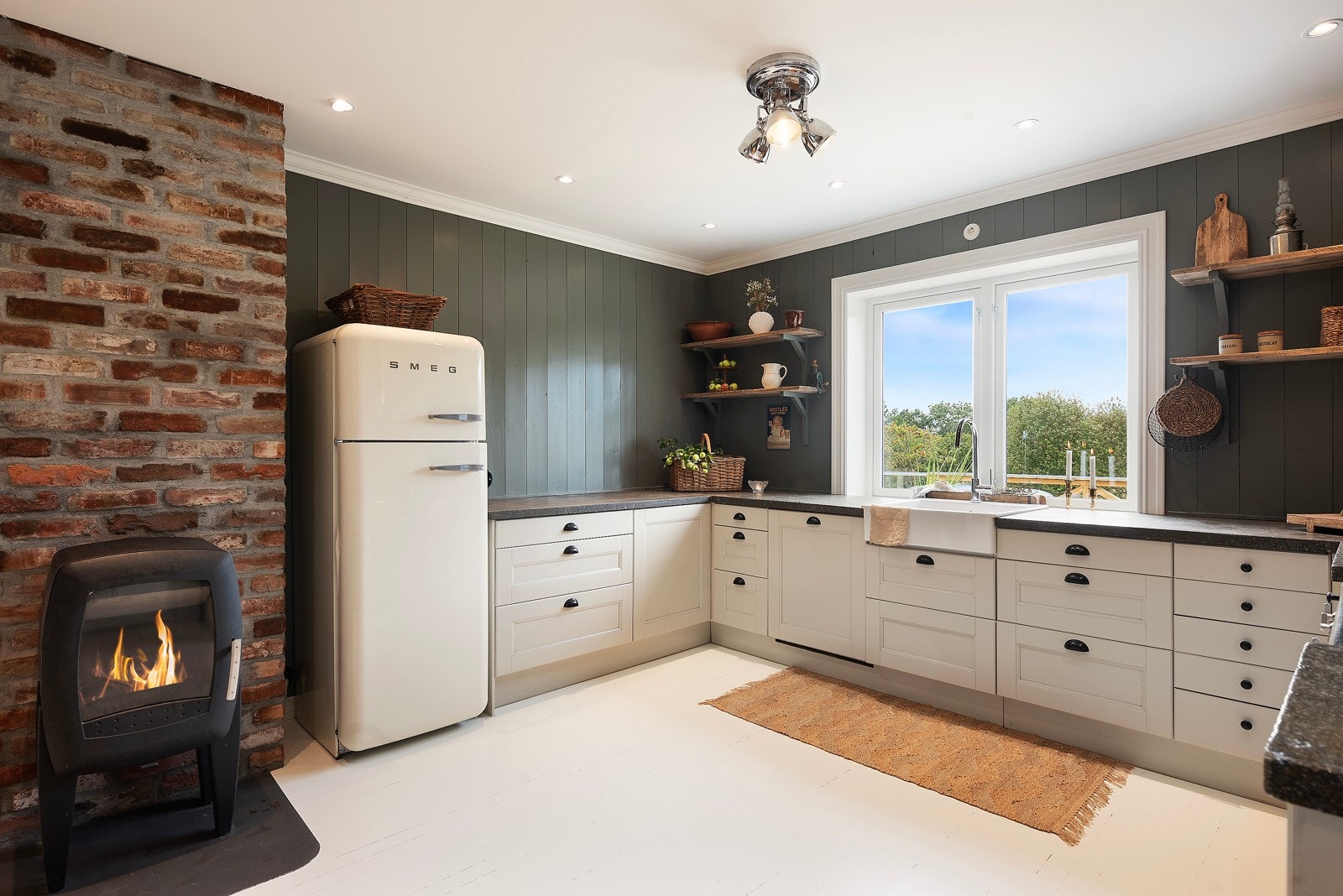 På kjøkkenet har du lyse profilerte fronter som står fint til de mørke veggene og den røffe pipen Galleribilde