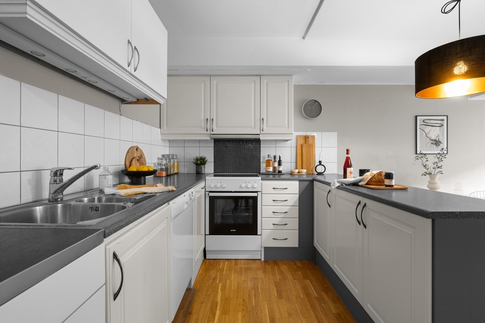 Kjøkken med hvitevarer som oppvaskmaskin, komfyr og kjøleskap med fryser. Galleribilde