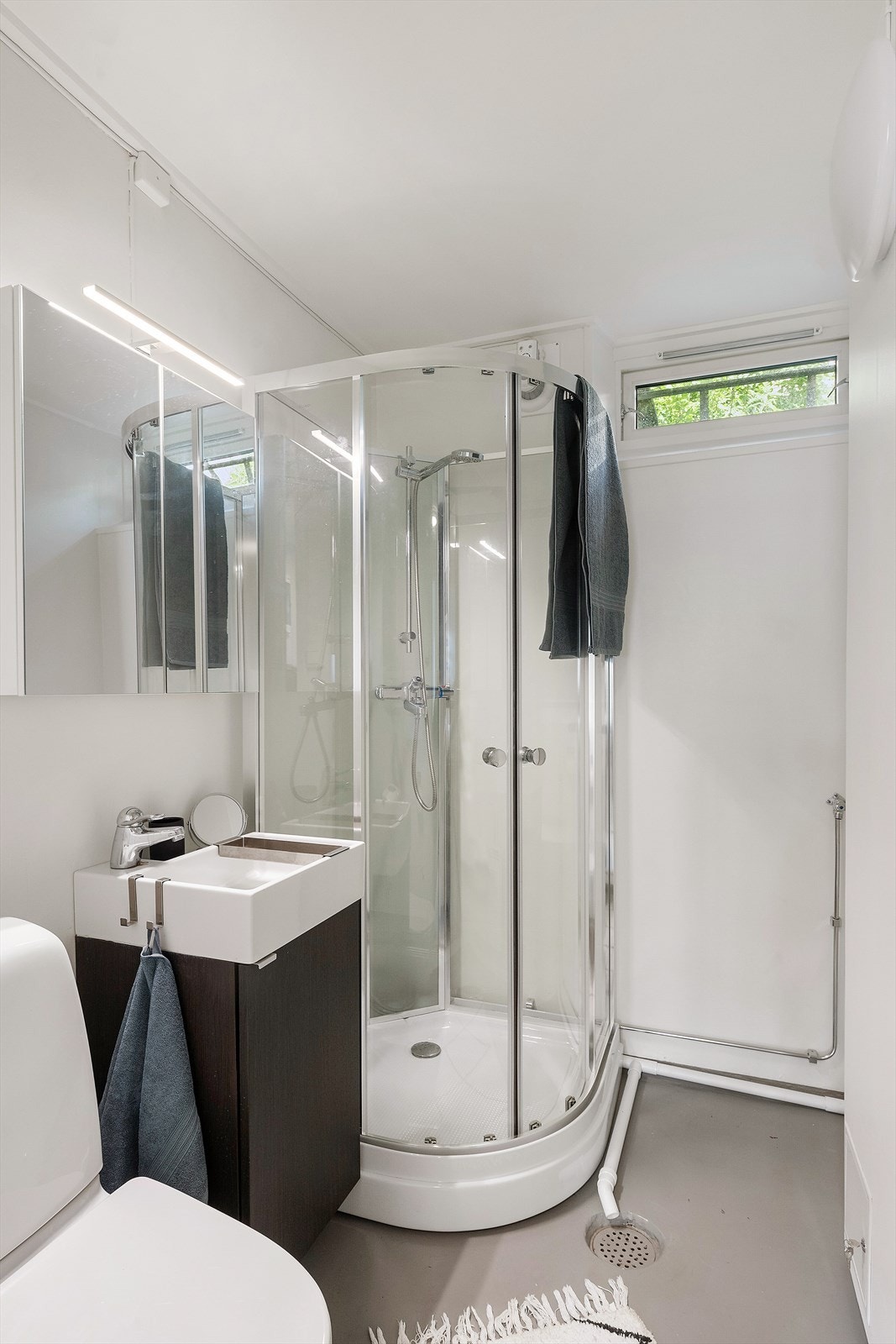 Badet er av grei størrelse og er innredet med dusjkabinett, toalett og baderomsinnredning. Galleribilde
