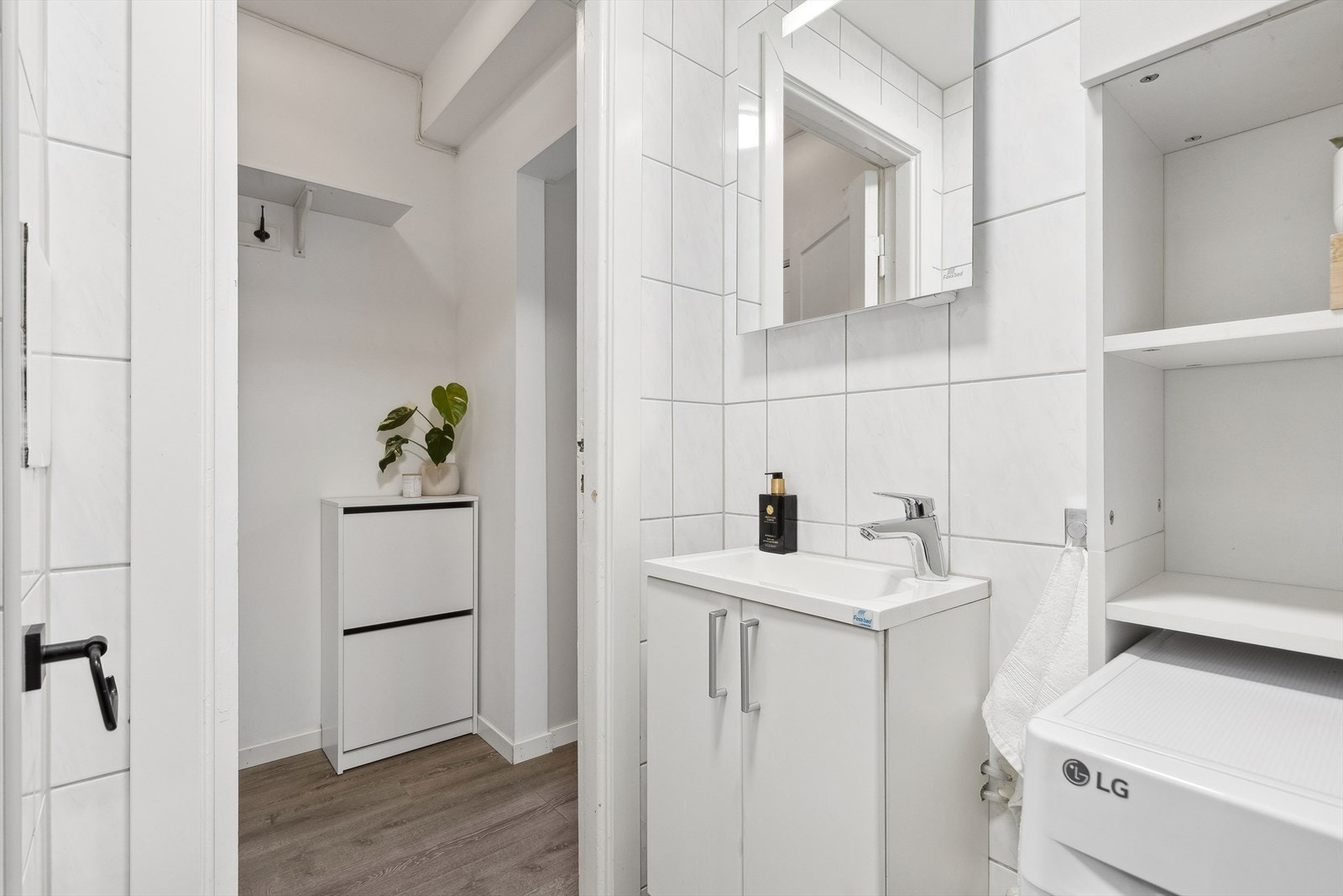 Badet har tidløse fliser på både gulv og vegger, samt varmekabler for ekstra komfort. Det er også utstyrt med et servantskap, speil med integrert belysning, og det er plass til vaskemaskin. Galleribilde