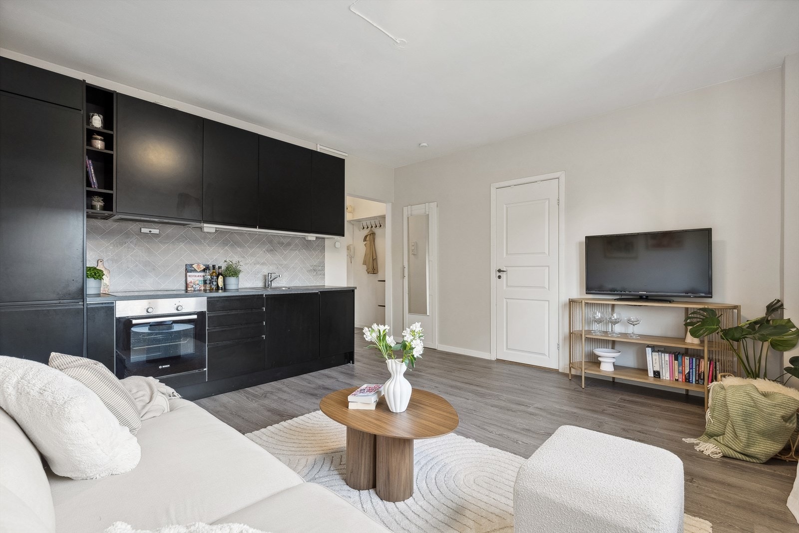 Rommet har en fleksibel utforming som gjør det enkelt å tilpasse innredningen etter behov, og det er godt med plass til både sofa, TV, TV -bord og spisebord med stoler. Galleribilde