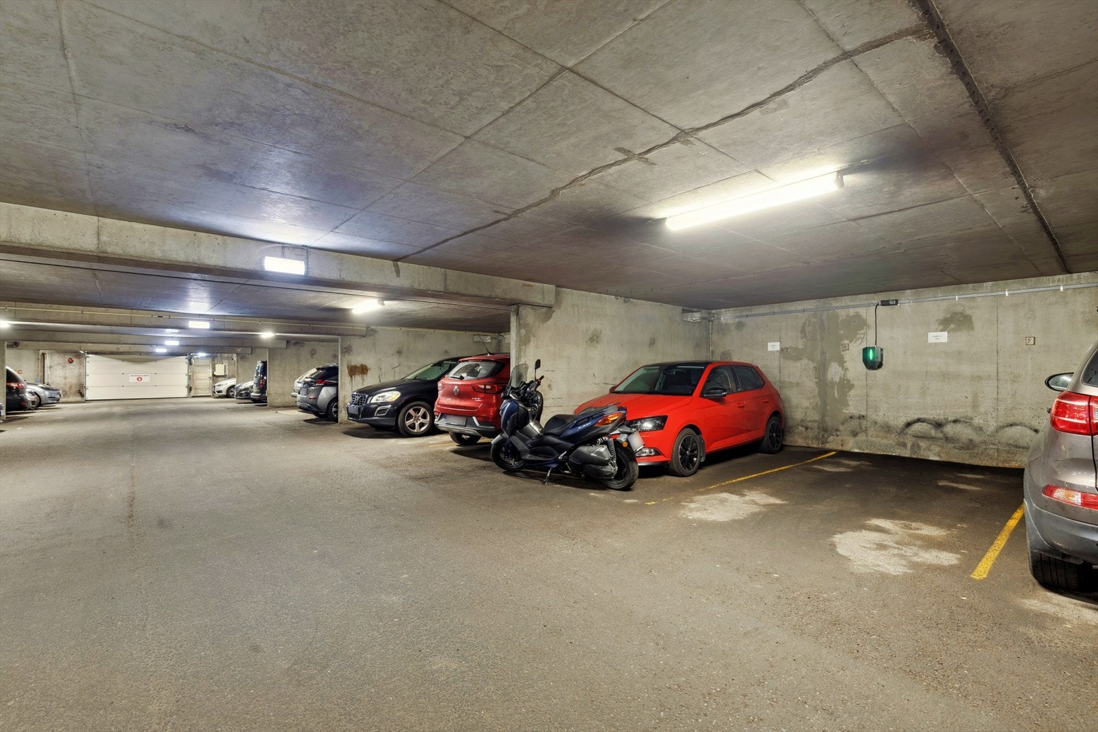 Leiligheten inkluderer en egen garasjeplass i felles garasjeanlegg, utstyrt med elbillader Galleribilde