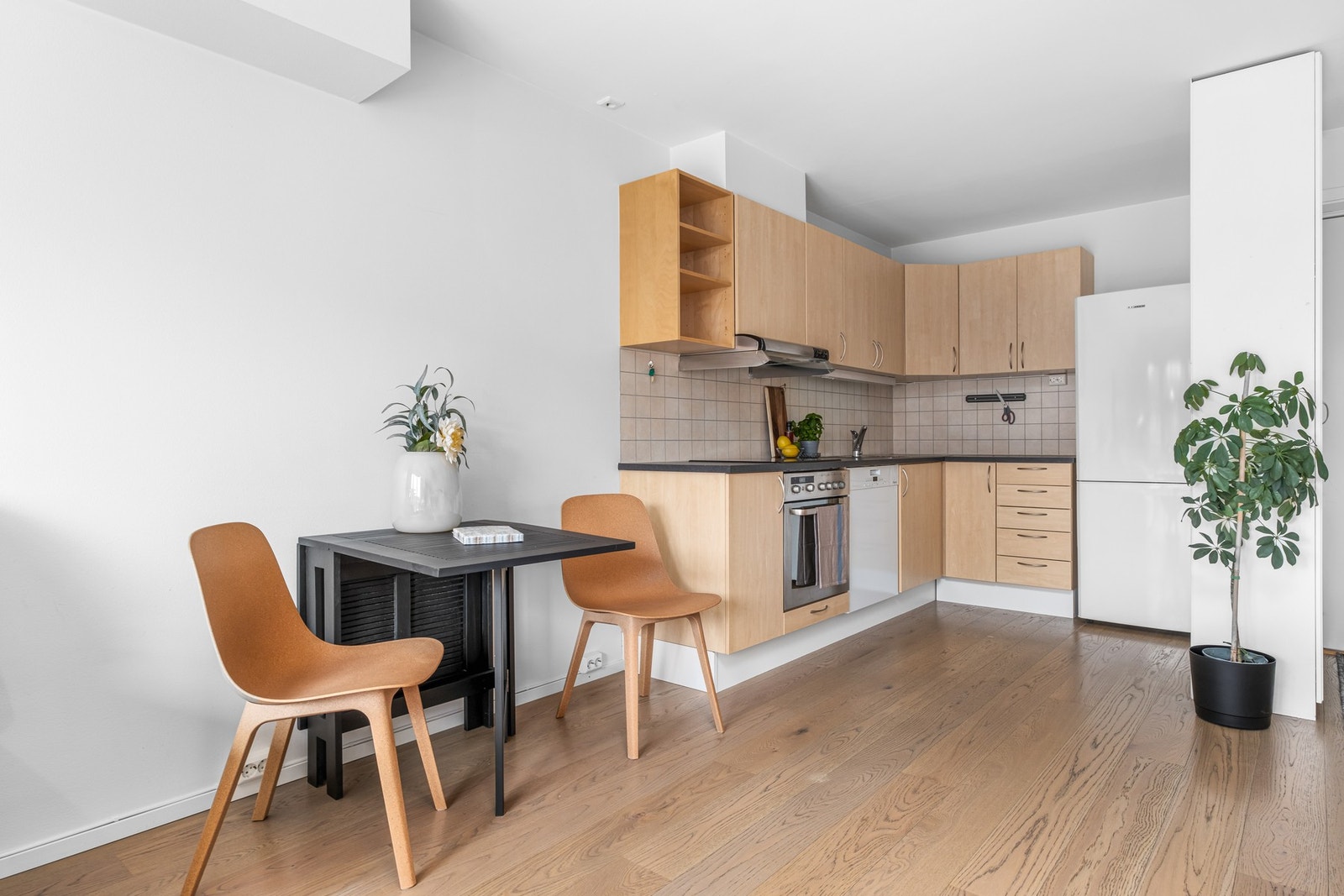 Pent kjøkken med integrerte platetopp, oppvaskmaskin og stekeovn. Galleribilde