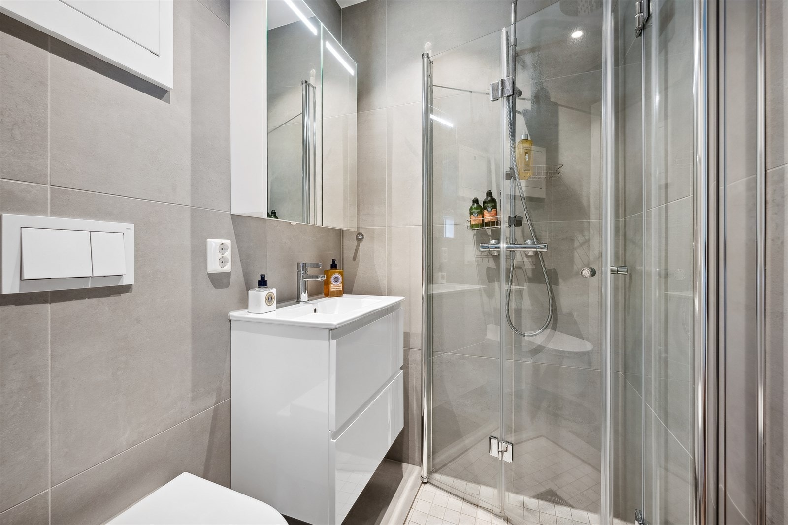 Delikat flislagt baderom totaloppusset i 2023 med elektriske varmekabler i gulv og downlights i himling. Badet er utstyrt med speilskap med lys, nedfelt servant, veggmontert toalett og dusjvegger/hjørne. Badet har naturlig ventilering. Galleribilde