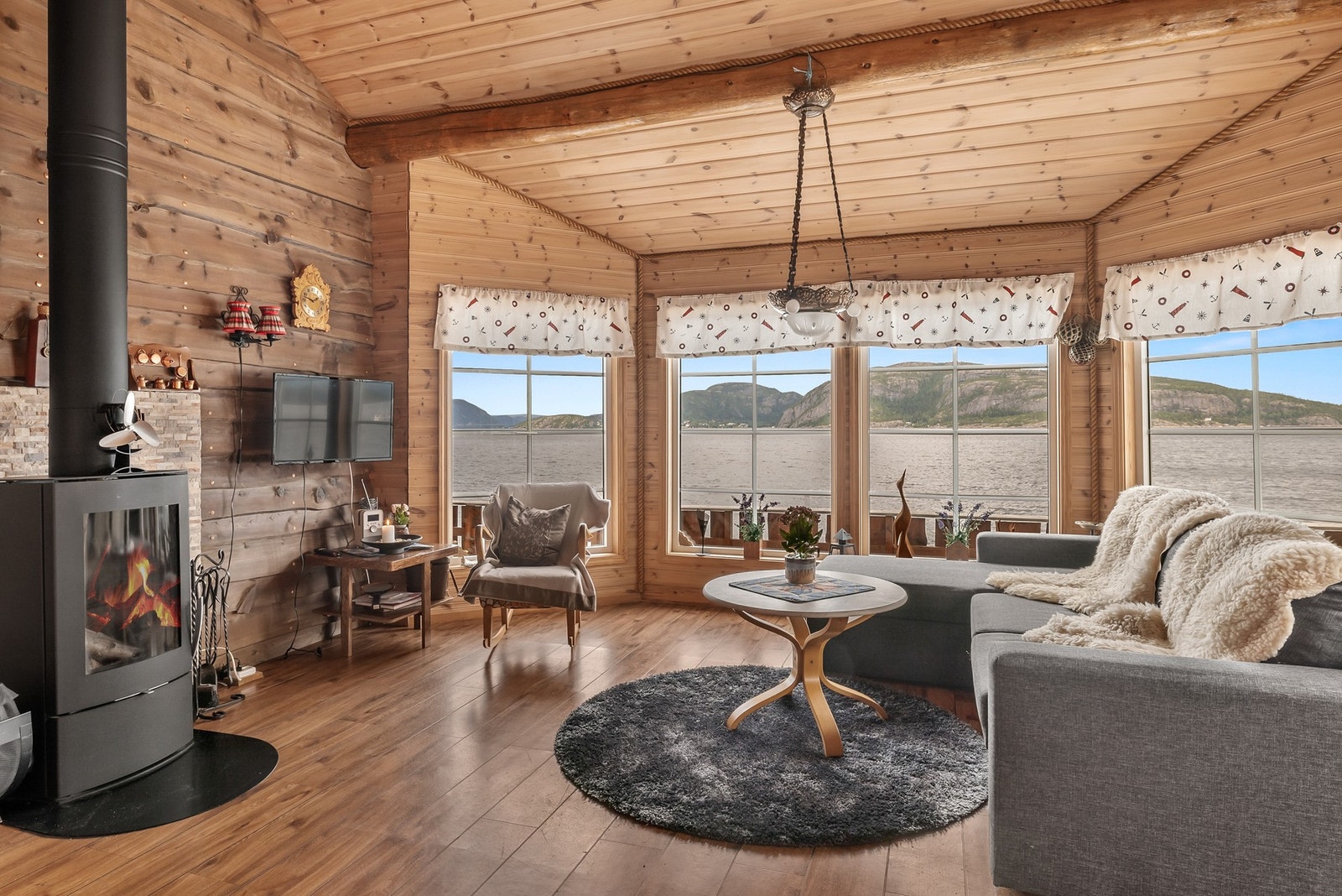 Stue med god takhøyde og store vindusflater som gir en god romfølelse Galleribilde