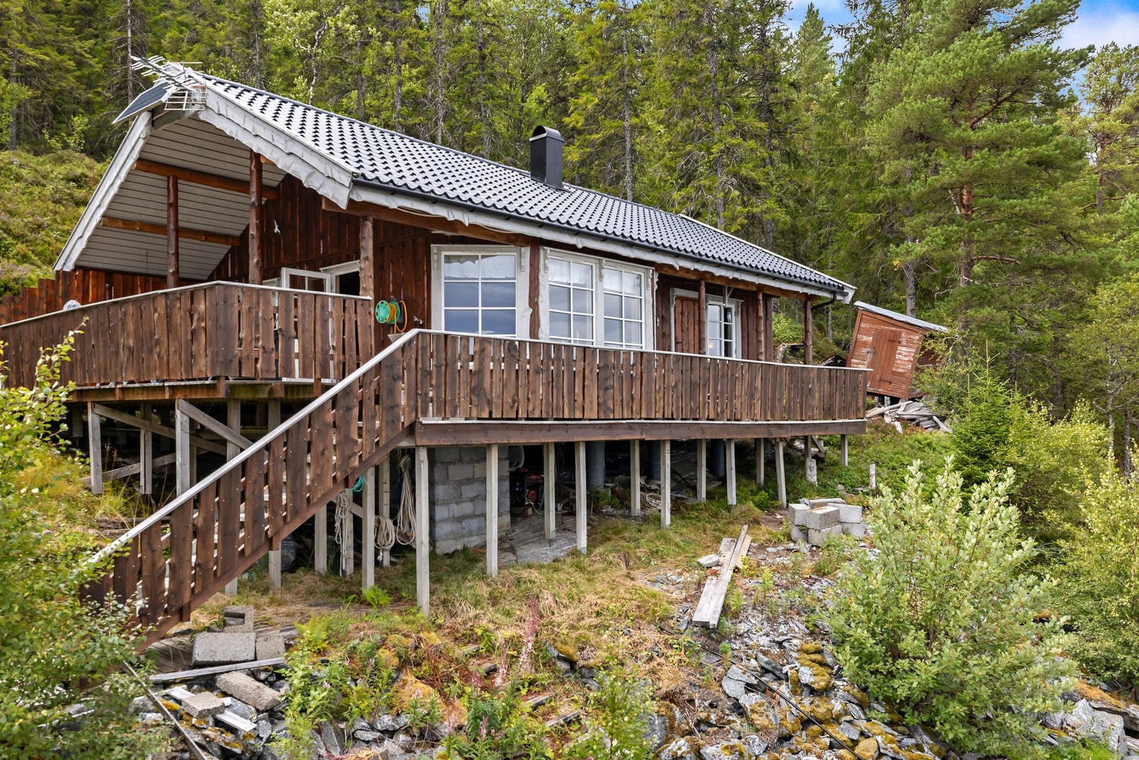 Veggene har bindingsverkskonstruksjon fra byggeår med fasade av stående kledning av villmarkspanel Galleribilde