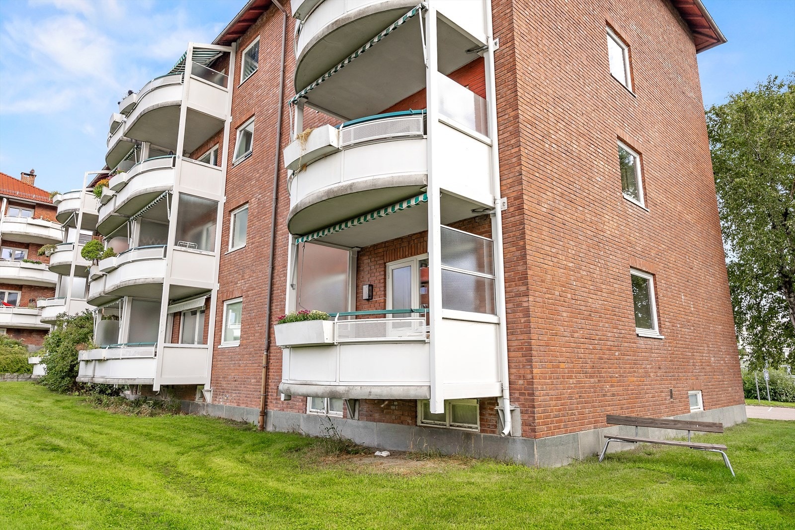 Bygningens fasade med balkonger og grøntarealer Galleribilde