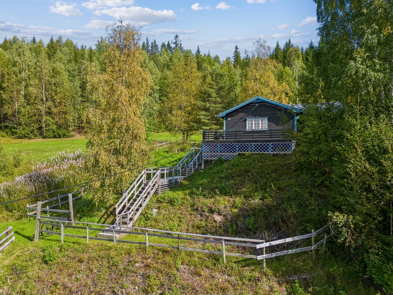 Tomten er inngjerdet og det er parkering på utsiden av gjerdet. Galleribilde