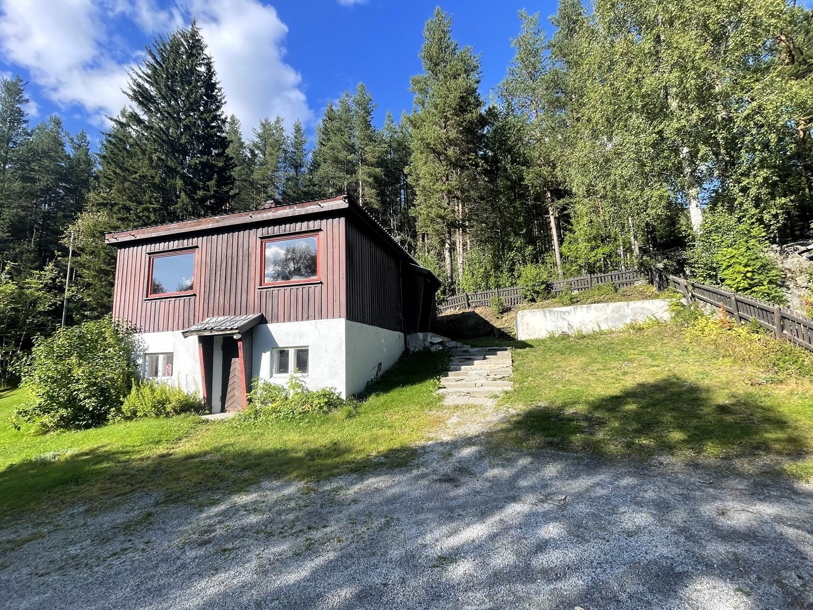 Opparbeidet tomt med bl.a. gruset oppkjørsel, gressplen og noe beplantning Galleribilde