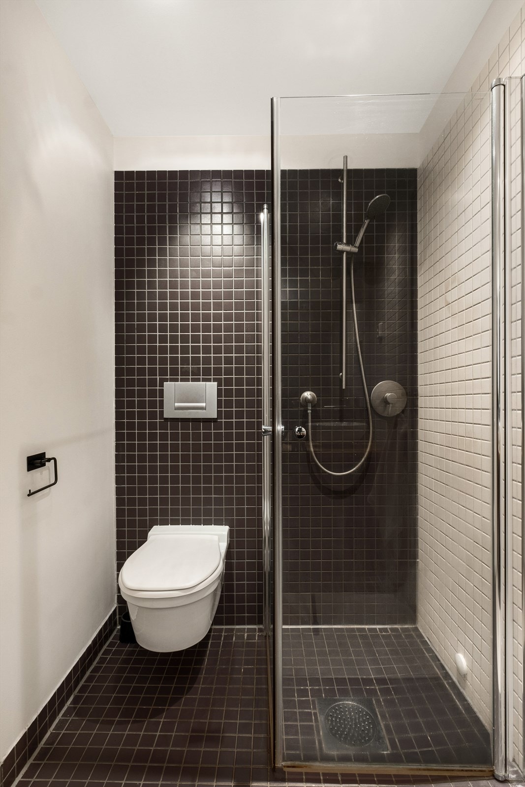 Badet er innredet med vegghengt klosett, servant på heltre benkeplate, speil og dusjhjørne med svingbare glassdører. Mekanisk avtrekk. Innfelte downlights. Galleribilde