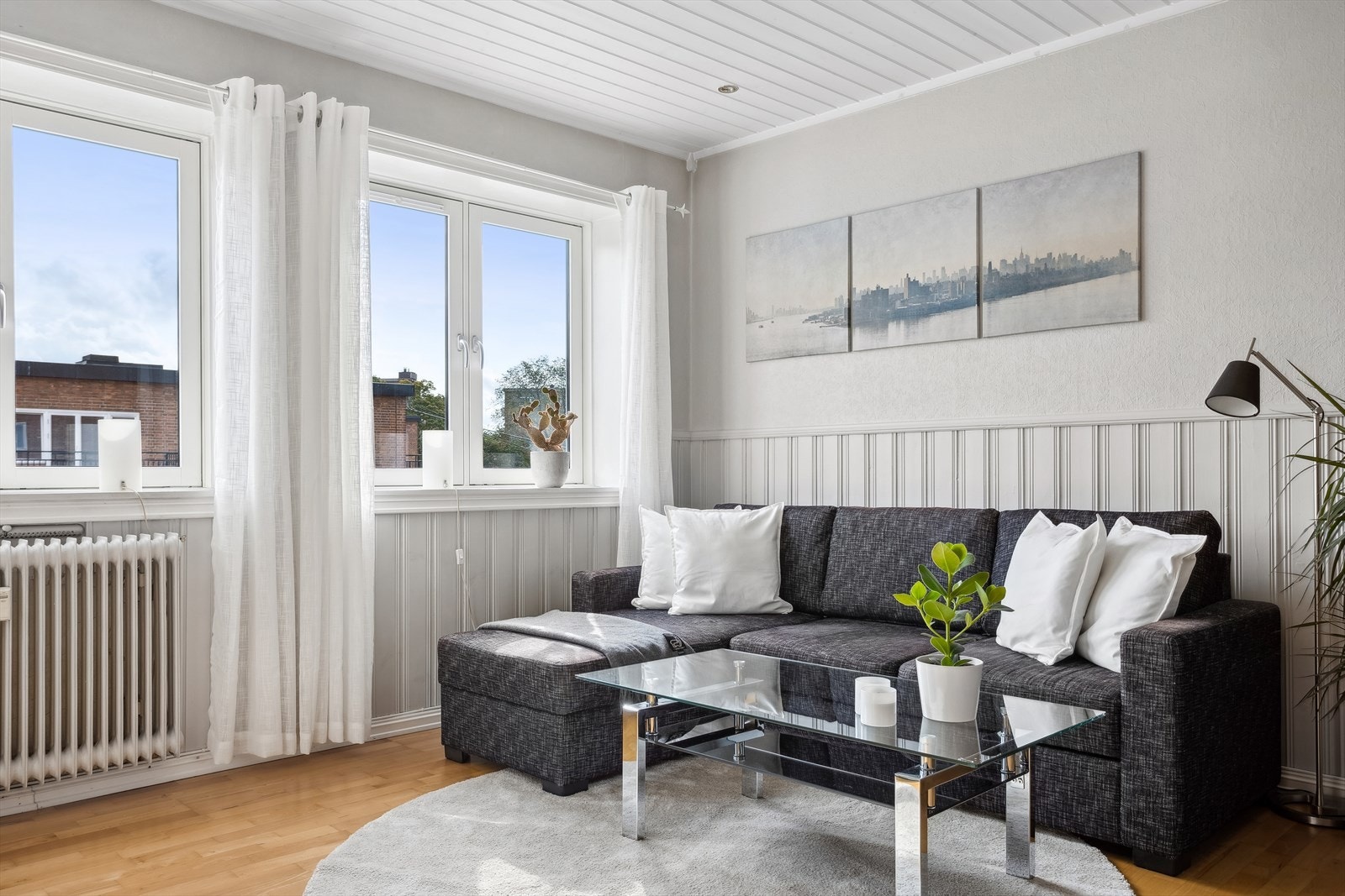 Leilighetens stue er lys og romslig, og gulv av parkett som gir et moderne preg Galleribilde