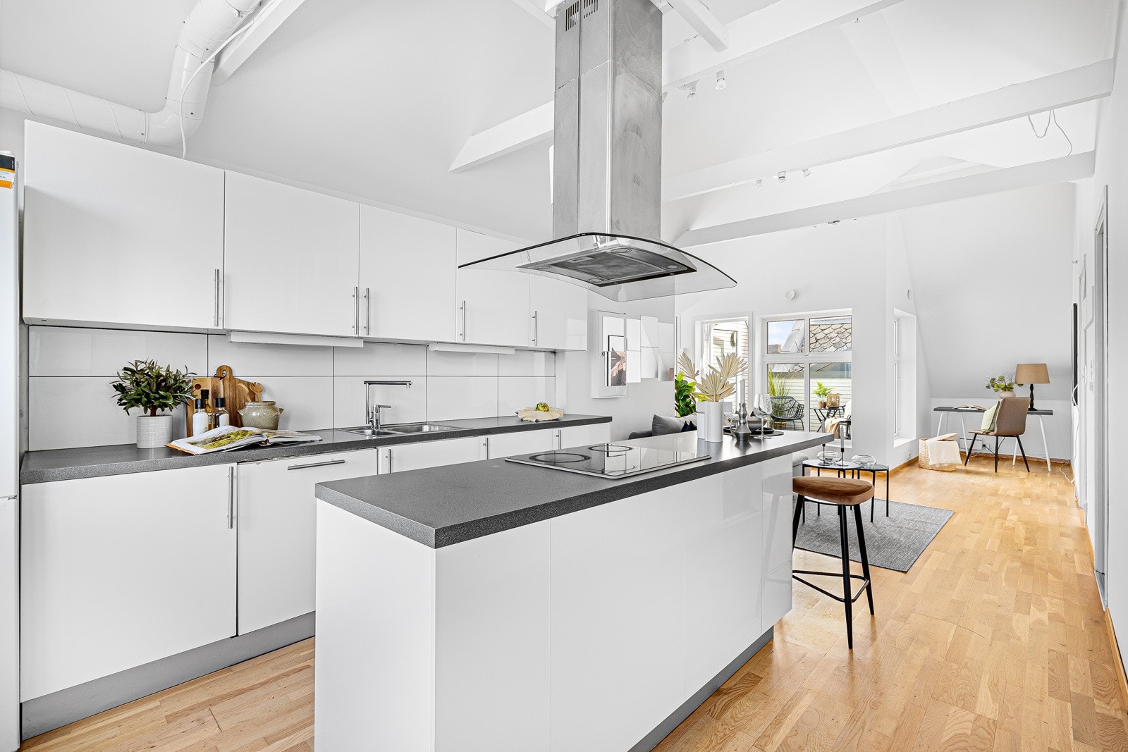 Lekkert kjøkken med hvite slette fronter og fliser mellom overskap og benk for å enkelt kunne holde det rent. Galleribilde