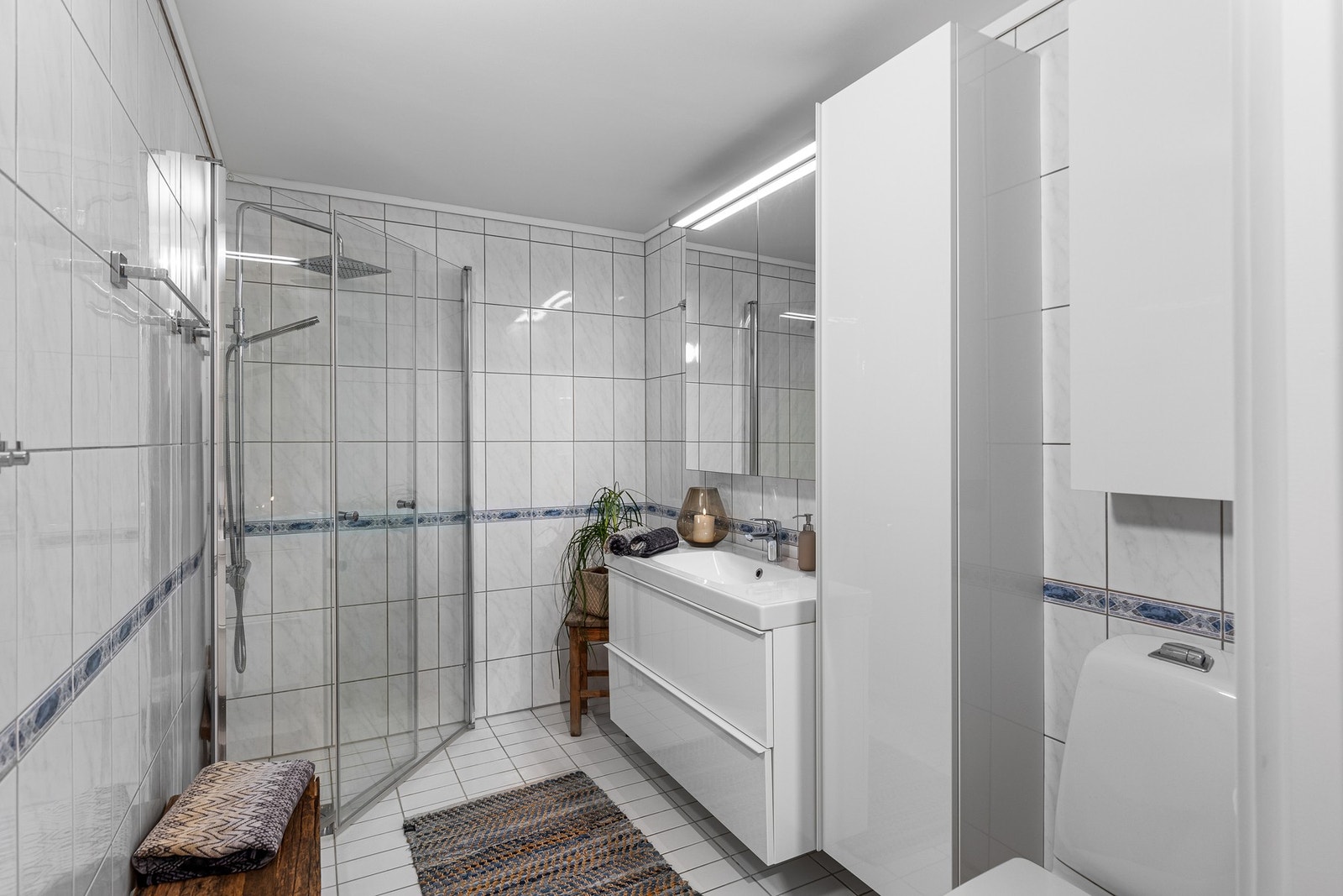 Badet er på 5 kvm med plassbesparende innfellbare dusjdører, samt servantmøblement med gode oppbevaringsmuligheter. Galleribilde
