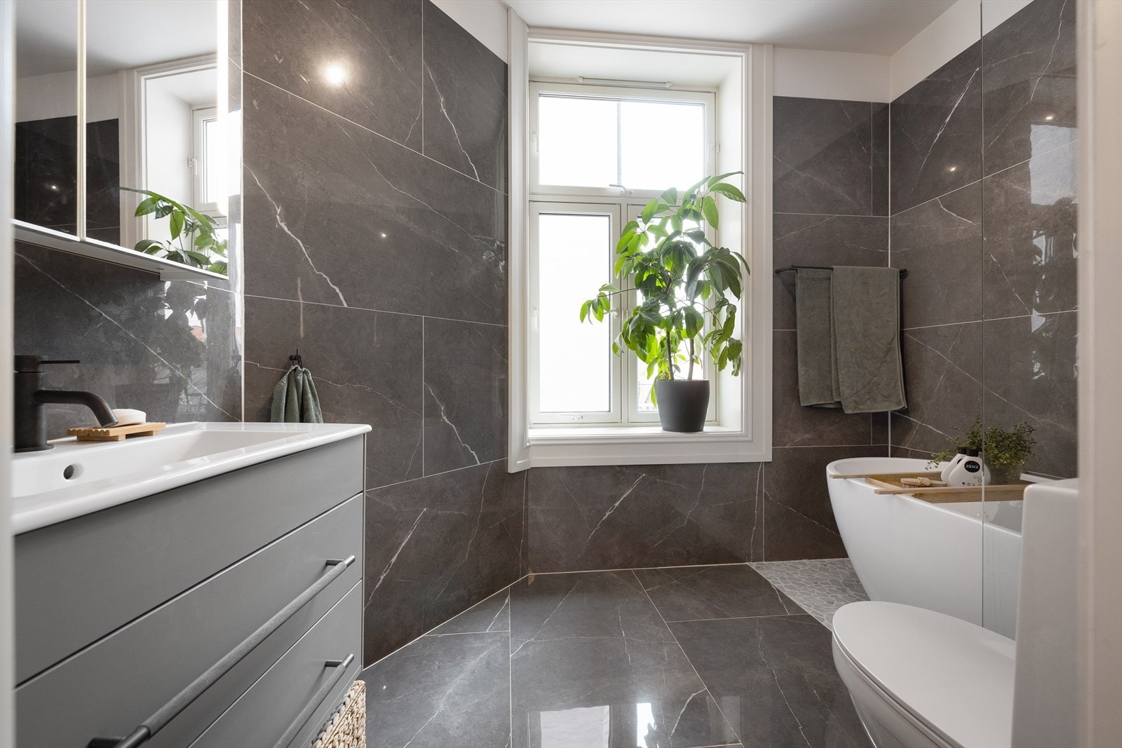 Romslig og pent flislagt bad med elektriske varmekabler Galleribilde