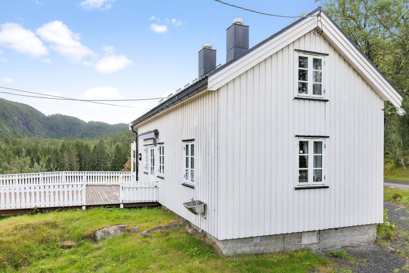 Tomten er opparbeidet med plen og gruset parkeringsareal. Galleribilde