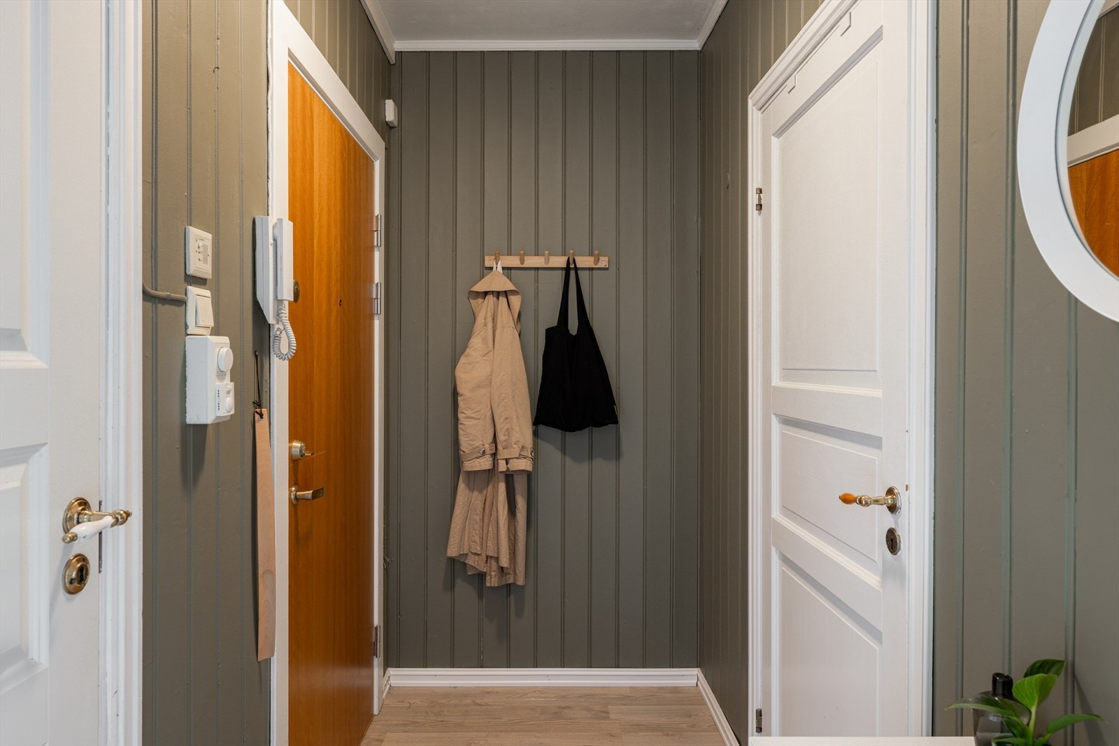 Entréen er praktisk og funksjonell med panel på veggene, samt plass til oppheng for yttertøy på knagger. Galleribilde