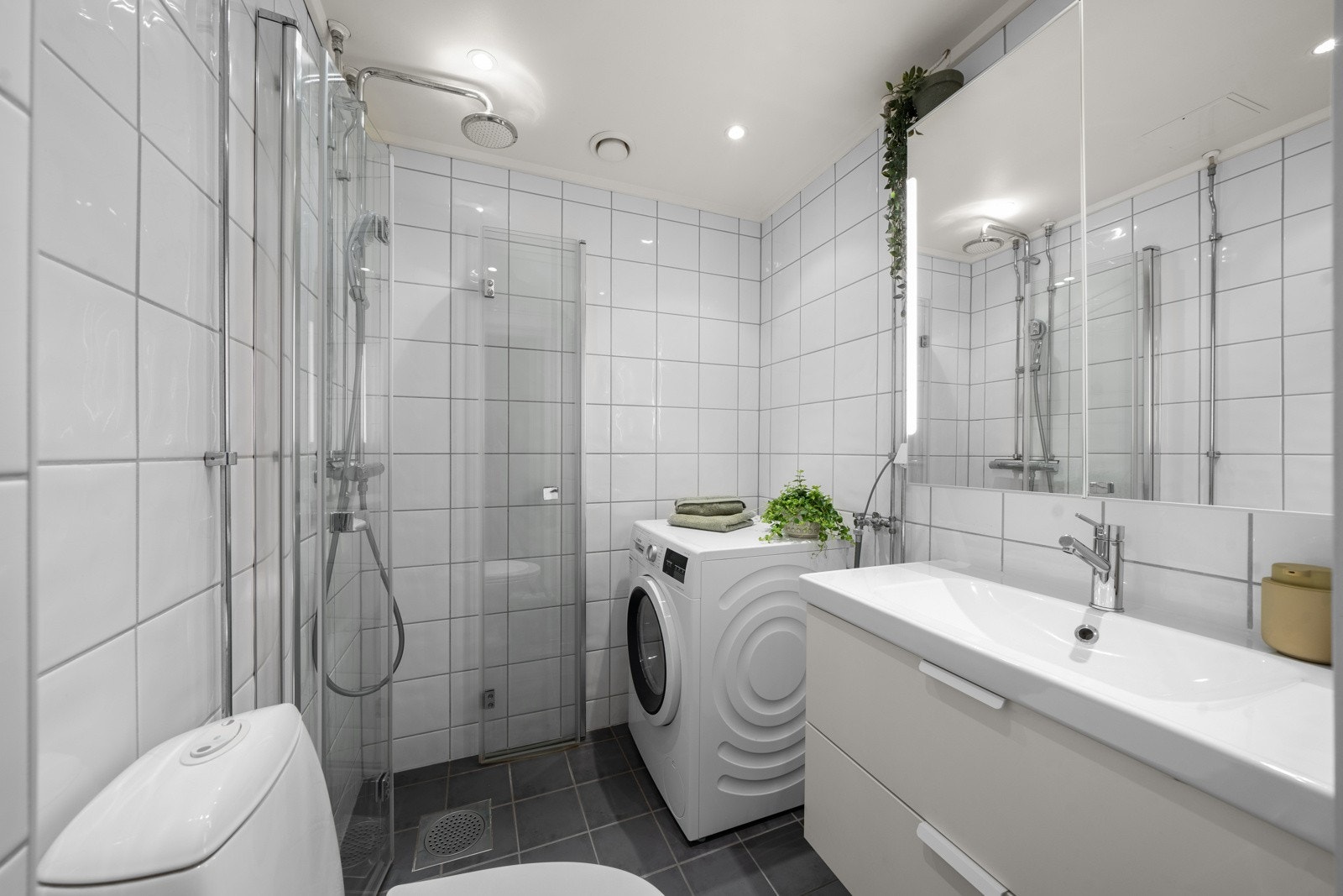 Nyt et moderne bad/vaskerom som er renovert i nyere tid! Her er det lagt fliser på gulv med varmekabler, samt flislagte vegger som skaper et rent og stilfullt uttrykk. Galleribilde