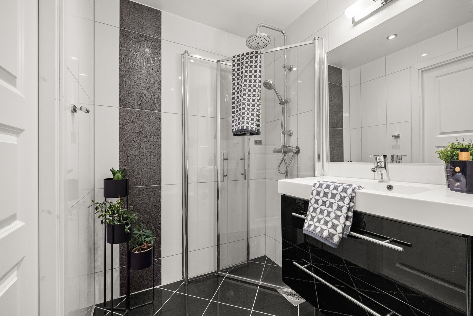 Badet er utstyrt med dusjhjørne, toalett og servant med skuffer Galleribilde