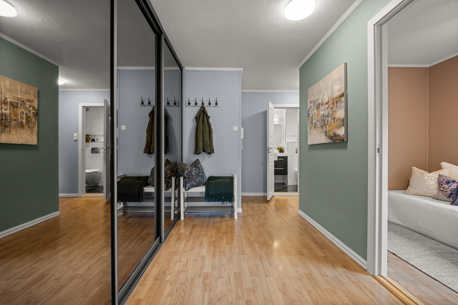 Velkommen inn til en romslig entrè med skyvedørsgarderobe Galleribilde