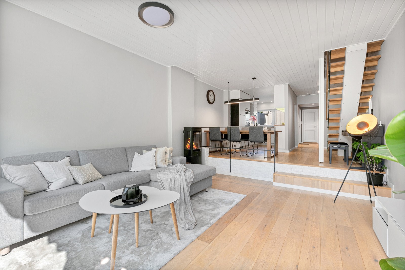Det er åpen løsning mellom kjøkken, spisestue og stue, men med et trinn ned til stueområdet. Det er montert både peisovn og varmepumpe i stuen. Galleribilde