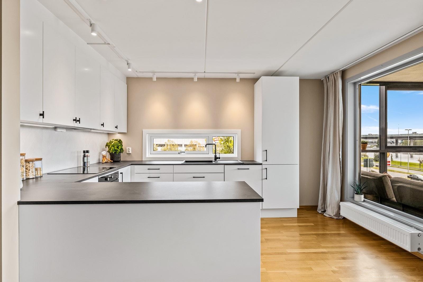 Fra stuen er det praktisk, åpen løsning til et delikat og moderne kjøkken med en romslig innredning. Galleribilde