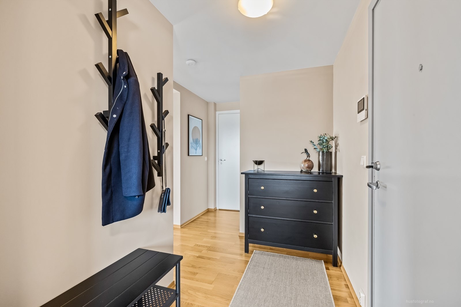 Velkommen inn! Leiligheten har en lys entré med parkett på gulv og lysmalte overflater. Galleribilde