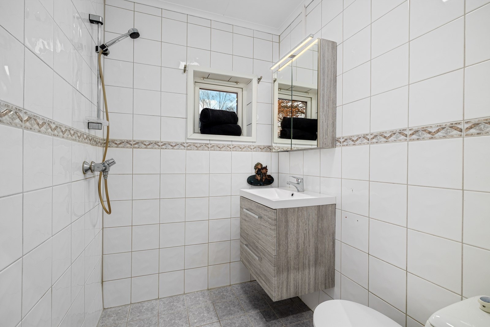 Baderom med flis på gulv og vegger. Galleribilde