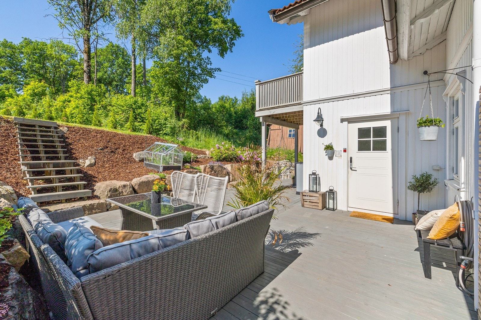 Terrassen ved inngangspartiet fremstår som en nydelig oase. Dette er virkelig en plass man kan sitte å nyte både blomster, stemning og sol. Galleribilde