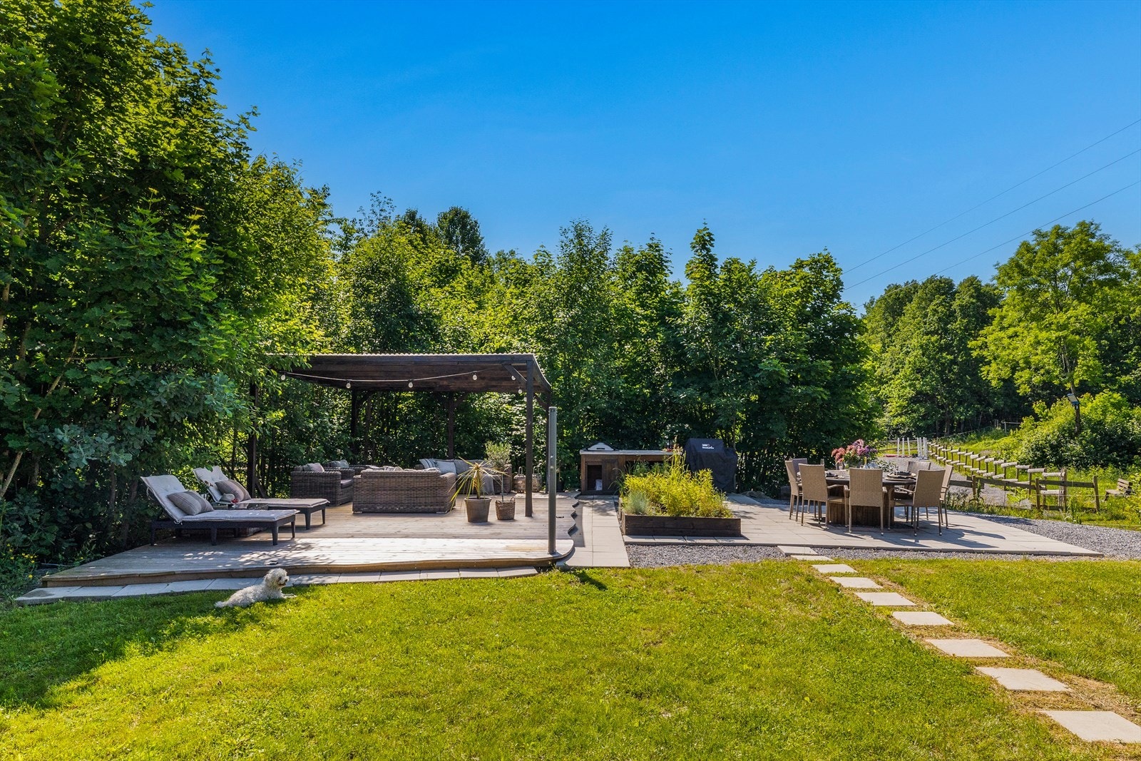 Stor og nyere impregnert terrasse m/dels overbygd pergola tekket med lysåpne plater. Sommerkjøkken og betongheller ved
sitteplasser. Galleribilde