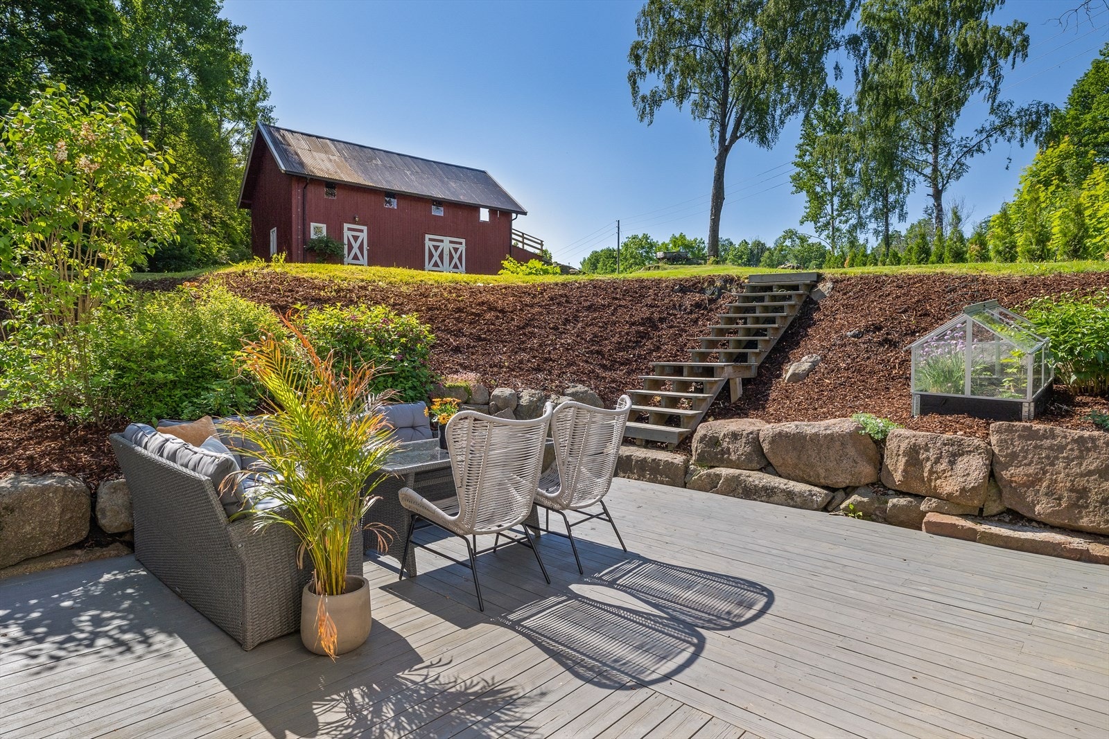 Tomten er møysommelig anlagt med diverse blomsterbed og variasjon av en rekke trær som pryder tomten. Galleribilde