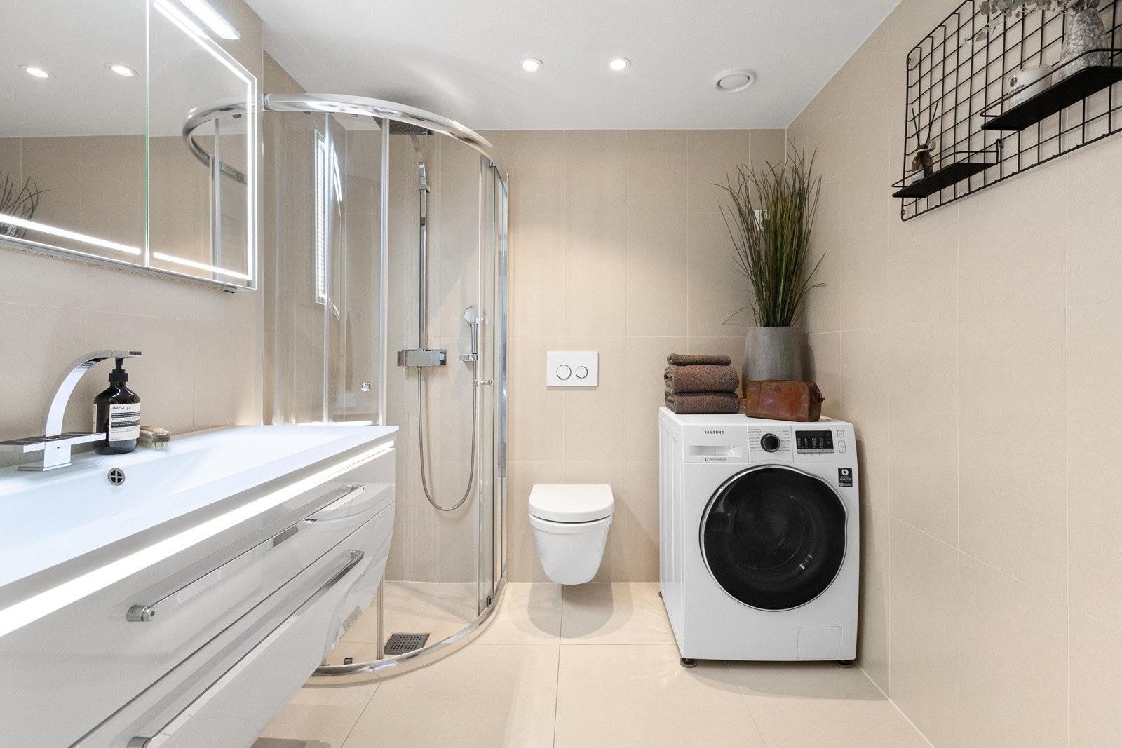 Delikat og flislagt bad med opplegg for vaskemaskin. Her er det også plass til benkeplate over vaskemaskin hvis man ønsker ekstra oppbevaringsmuligheter. Galleribilde