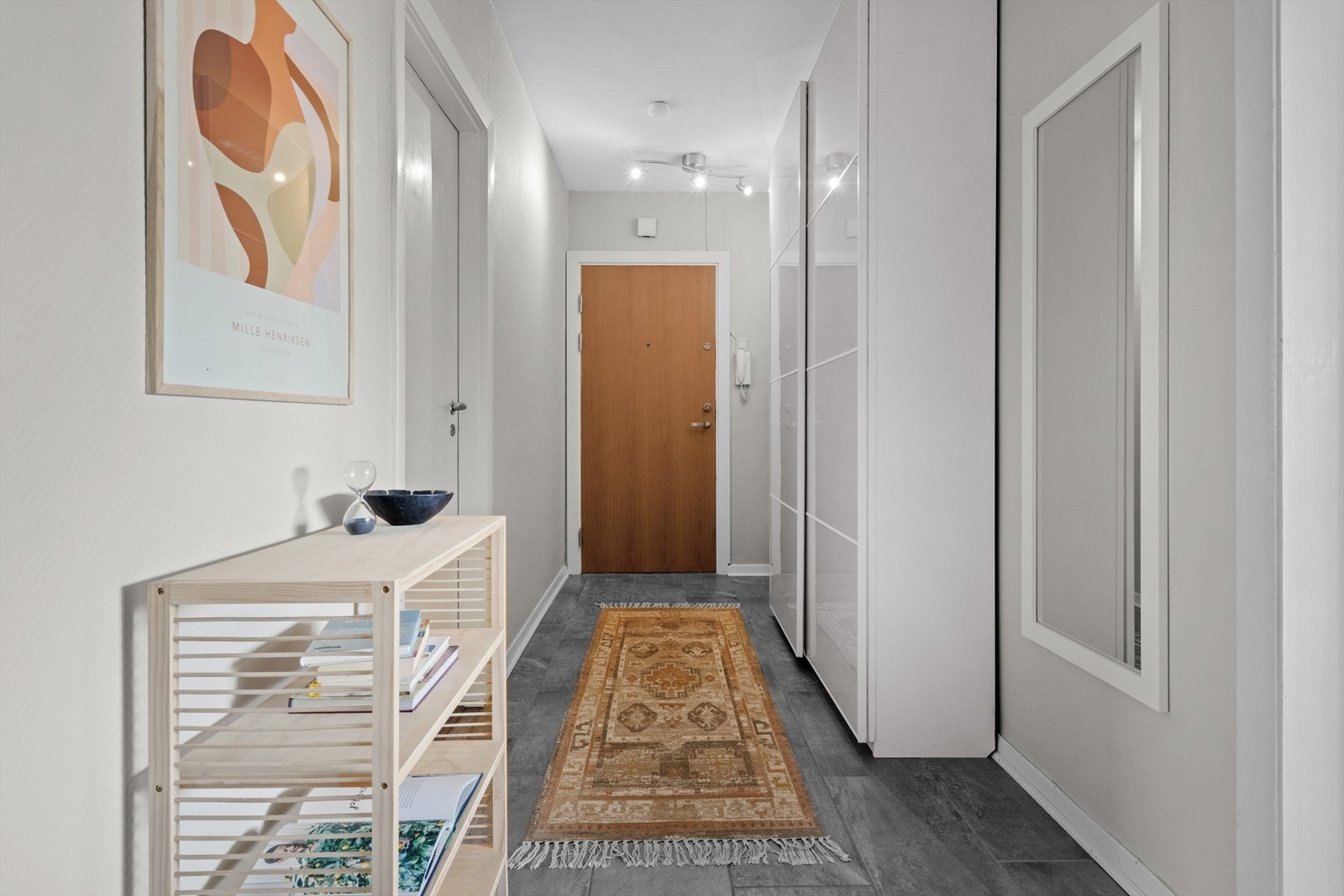 Leilighetens entré er flislagt, og har god plass til å henge fra seg klær og sette fra seg sko. Skyvedørsgarderobe med glatte fronter medfølger. Galleribilde