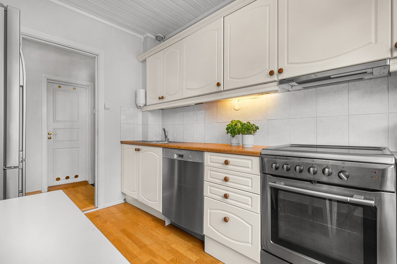 Lyst kjøkken med profilerte fronter. Det er godt med skap- og benkeplass. Galleribilde