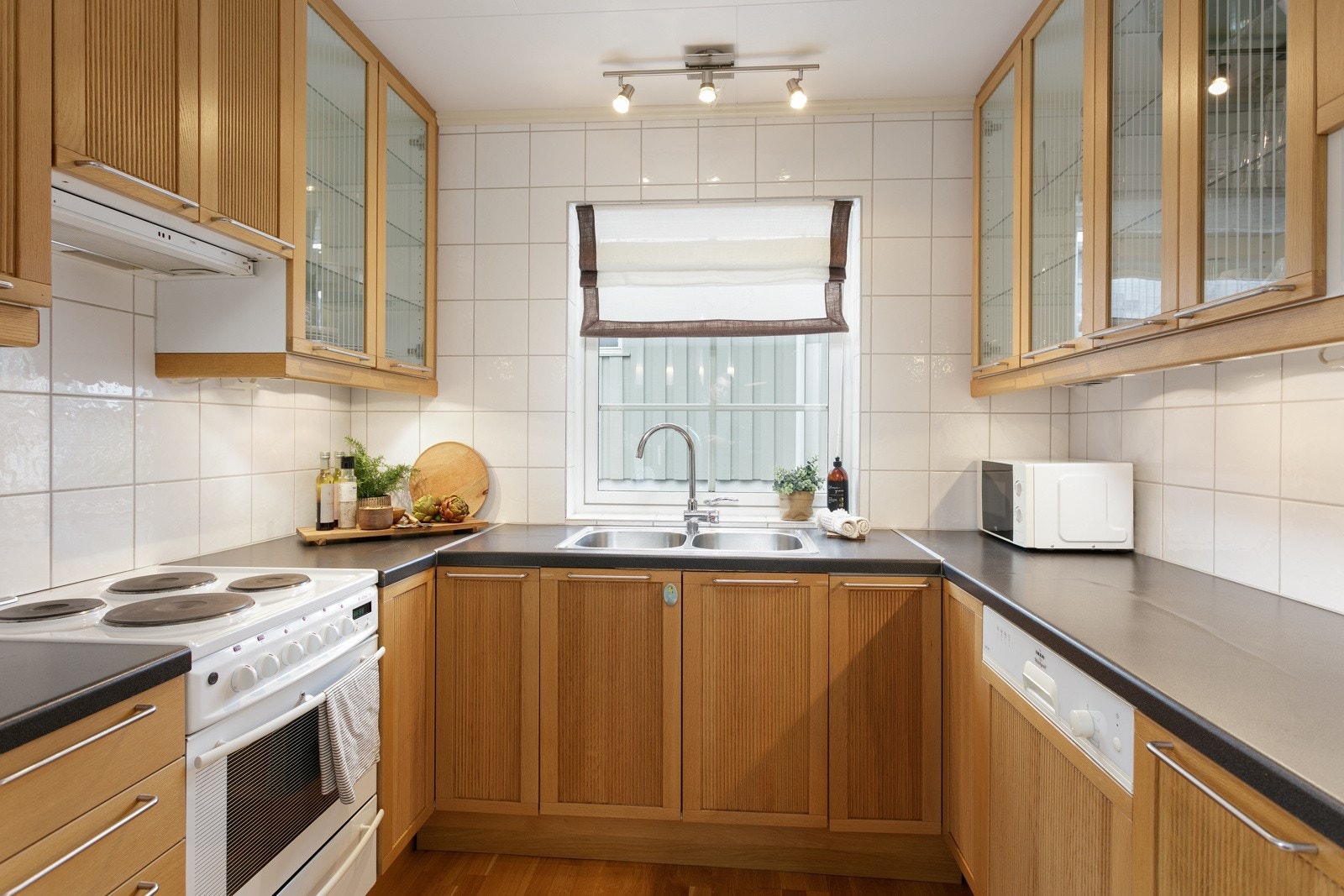 Det medfølger integrert oppvaskmaskin i kjøkkenet, legg merke til glassfronter på overskap Galleribilde