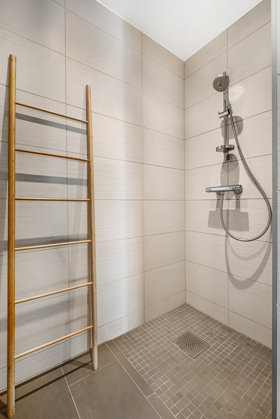 Badet er innredet med vegghengt toalett, nedsenket dusjhjørne, servant i innredning med benkeplate i tre, samt overskap med speil. Galleribilde