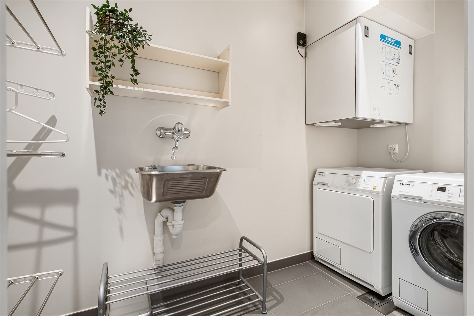 Vaskerom: dimmerstyrte downlights i himling, malte slette vegger og fliselagt gulv. Utslagsvask, opplegg for vaskemaskin og tørketrommel. Ventilasjonsenhet (Flexit). Enkel tilgang til sluk. Observert membran under klemring som tyder på fagmessig utførelse Galleribilde