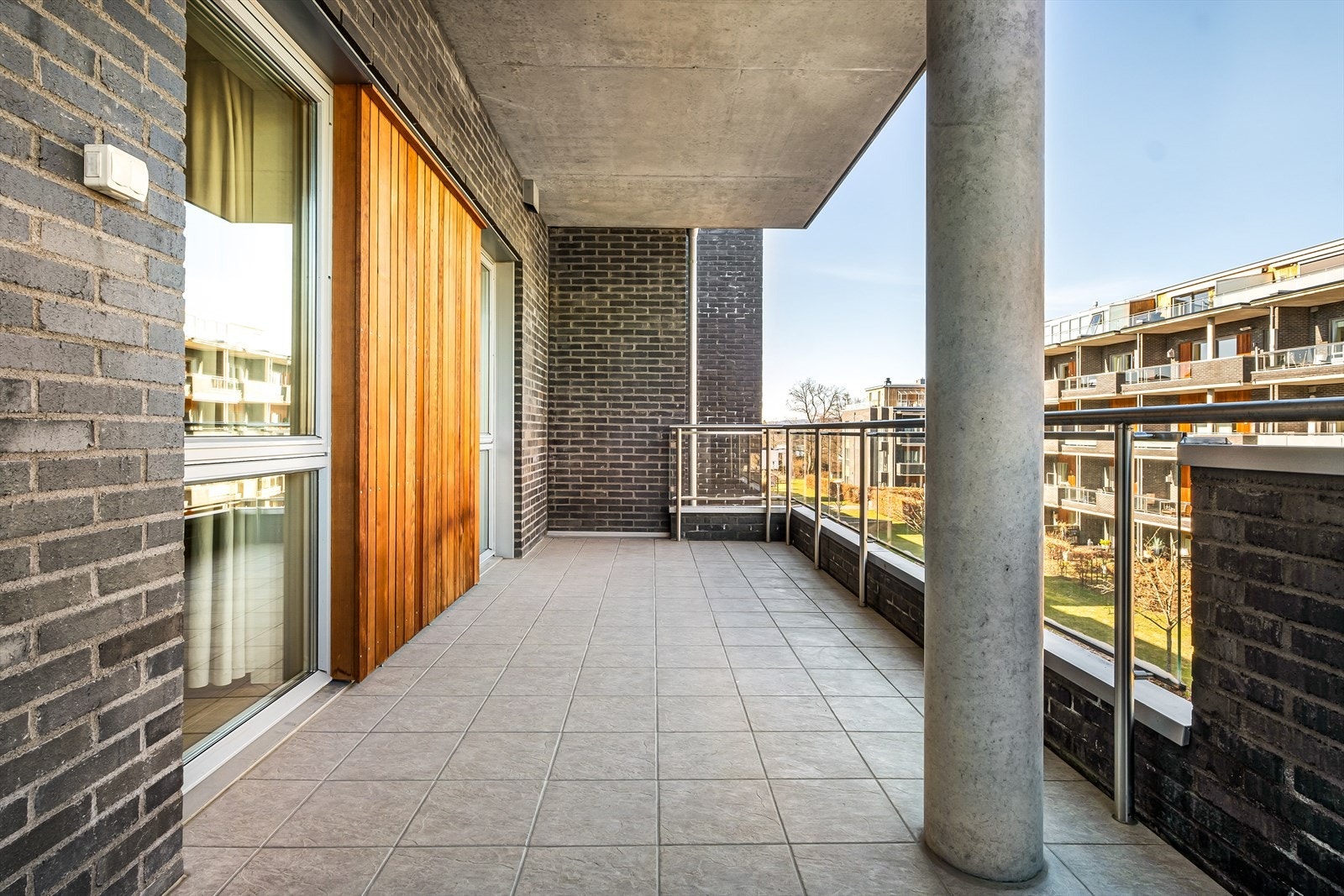 Balkong på ca. 15 kvm, med flislagt gulv og rekkverket av teglstein samt i rustfritt stål med glassplater. Galleribilde