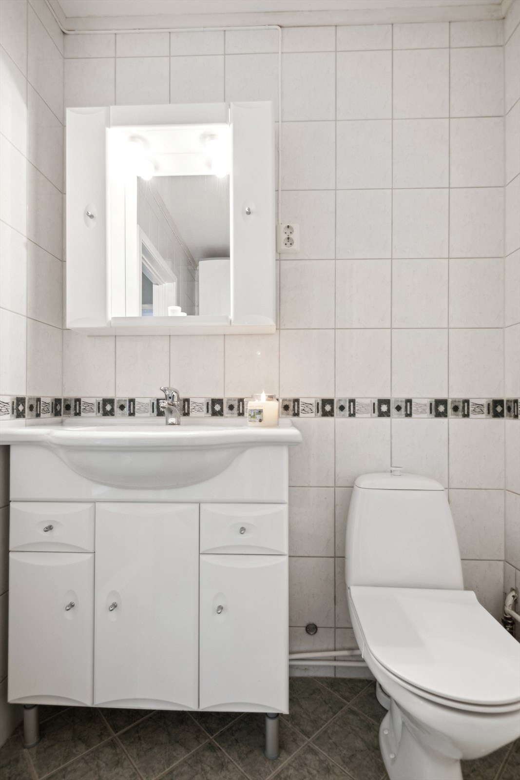 Badet er innredet med servantmøblement, toalett og dusjkabinett Galleribilde