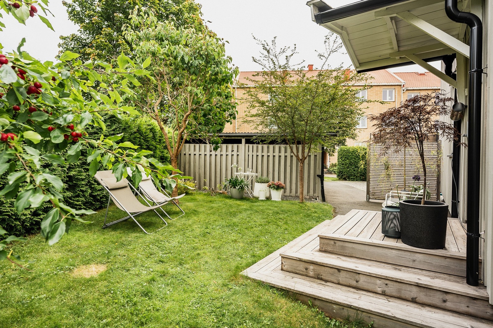 Idyllisk hage med terrasse og beplantning. Galleribilde