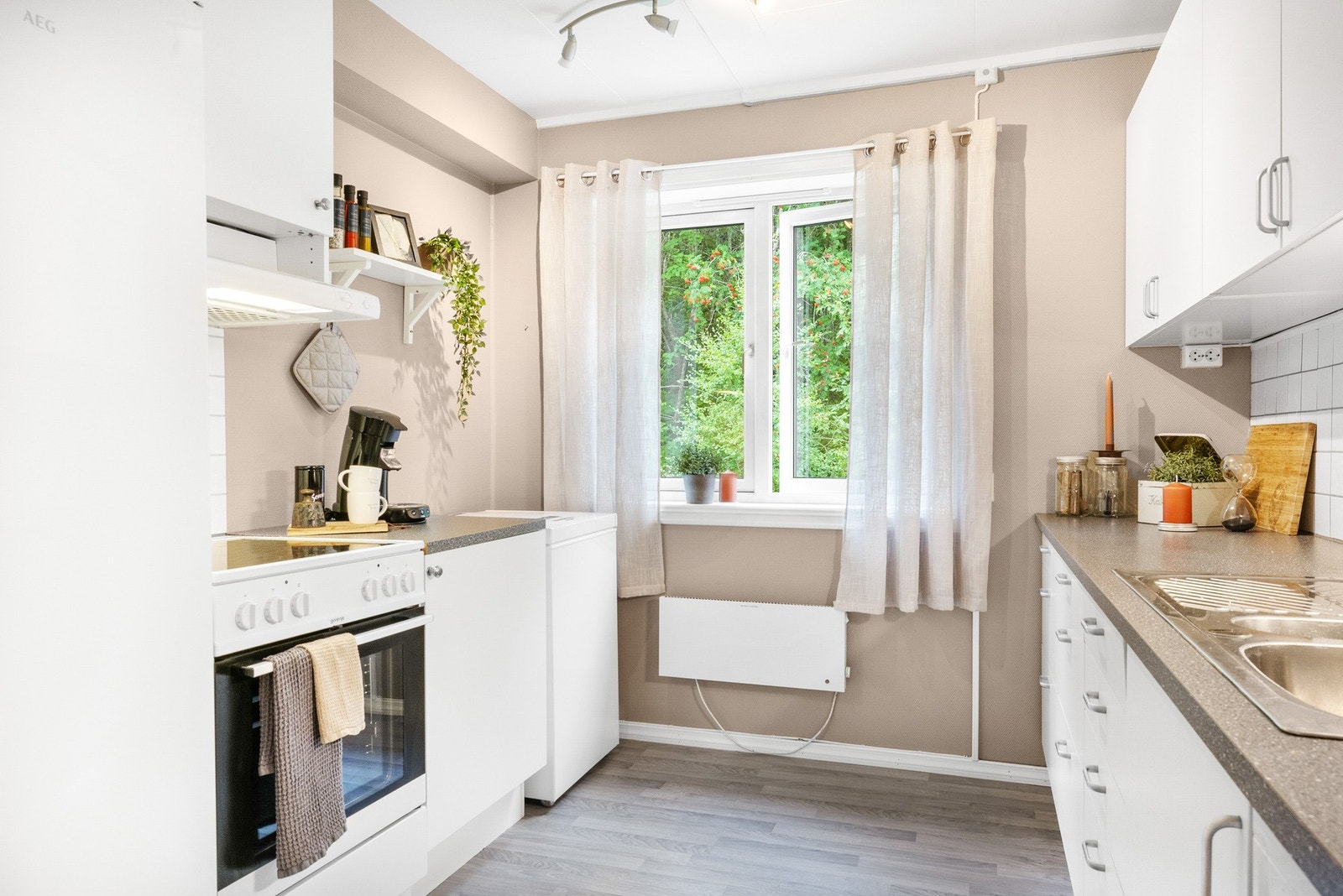 Kjøkkenet har innredning med glatte hvite fronter og benkeplate av laminat . Galleribilde