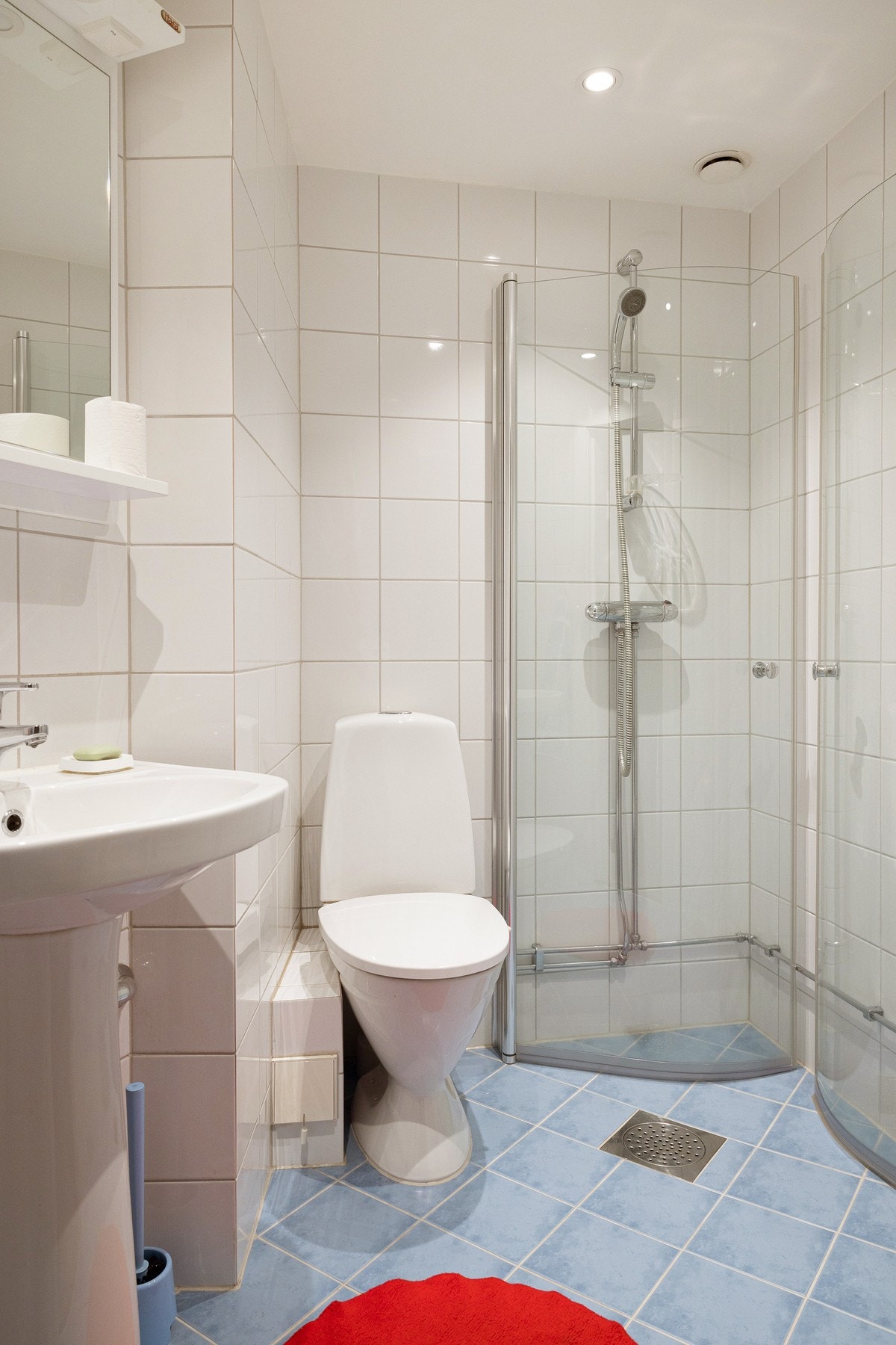 Lyst og pent baderom fra 2010. Baderommet har blå fliser på gulv med varme i og hvite fliser på gulv. Galleribilde