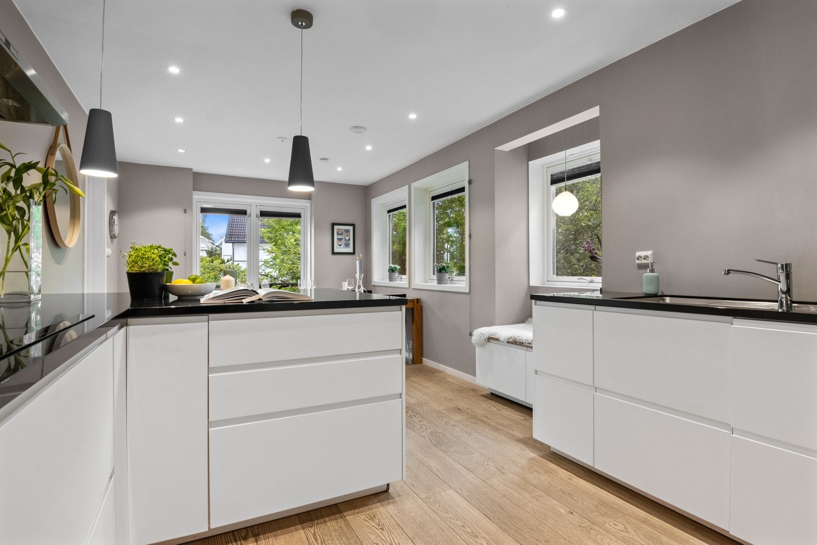 De stilrene frontene i hvitt er slette med grep på toppen, mens benkeplatene er av lekker, sort granitt. Alle hvitevarer er integrert Galleribilde