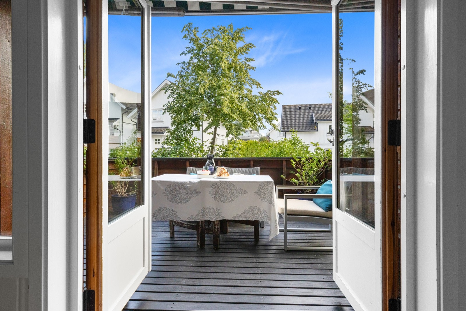 Vinduer i to retninger bidrar til fine lysforhold gjennom dagen og en tofløyet dør fører ut til veranda Galleribilde